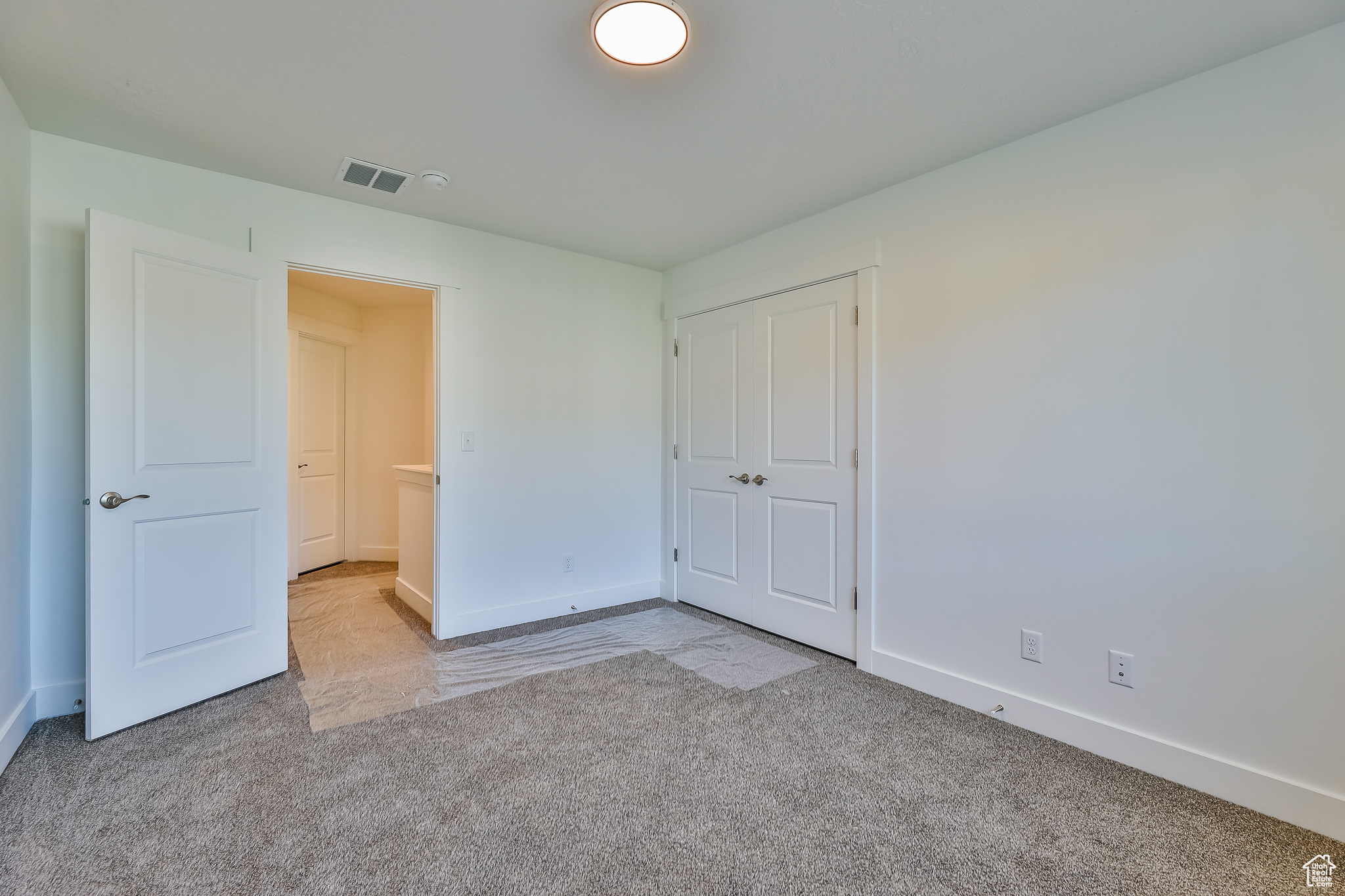 Unfurnished bedroom with a closet and light colored carpet