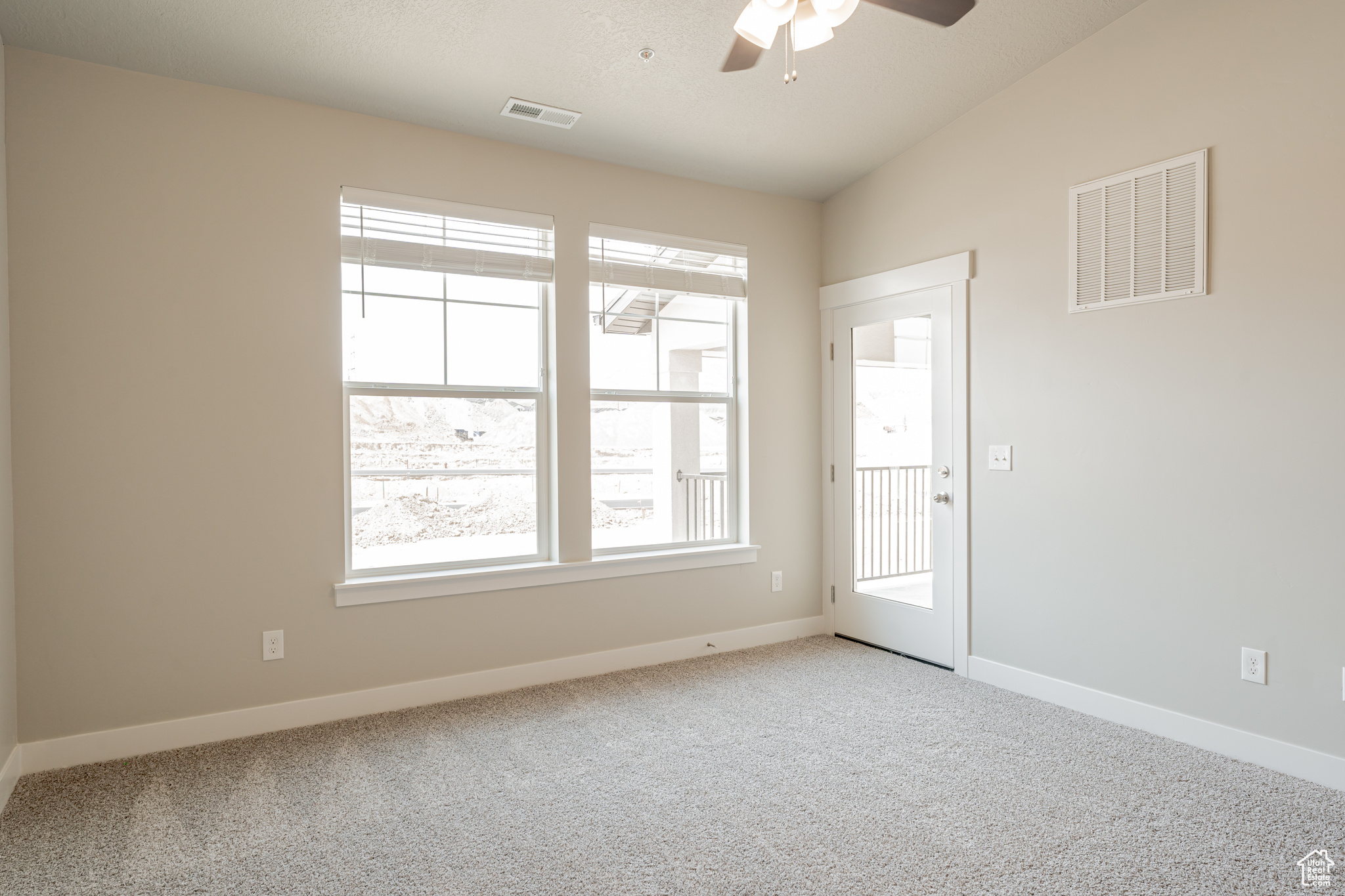 Carpeted empty room featuring ceiling fan