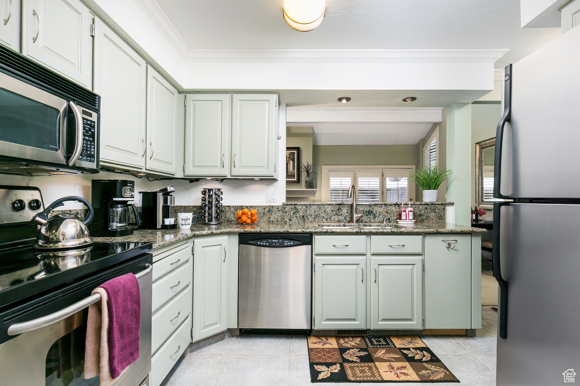Kitchen featuring ornamental molding, granite countertops, and appliances with stainless steel finishes