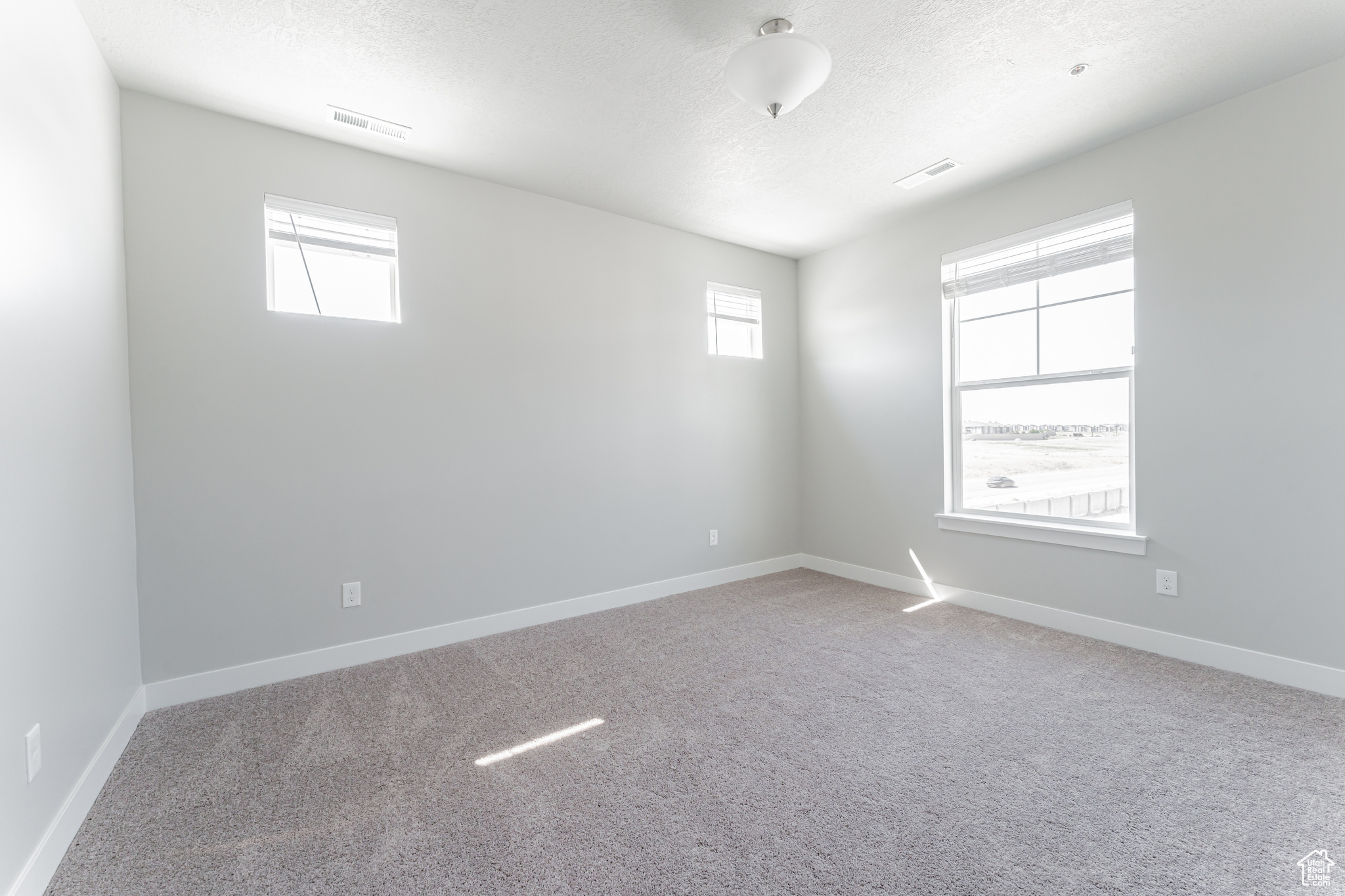 Carpeted empty room with a textured ceiling