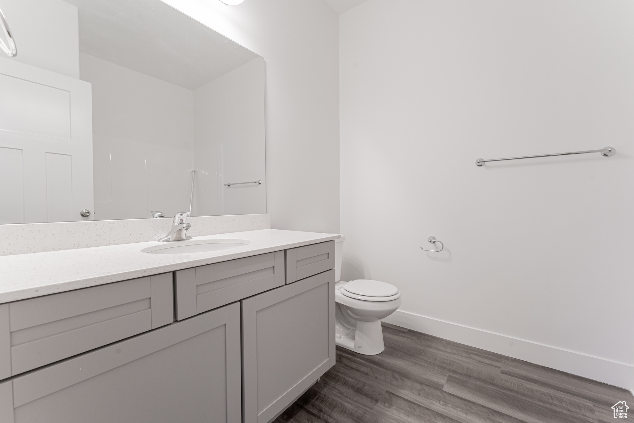 Bathroom featuring vanity, toilet, and hardwood / wood-style floors