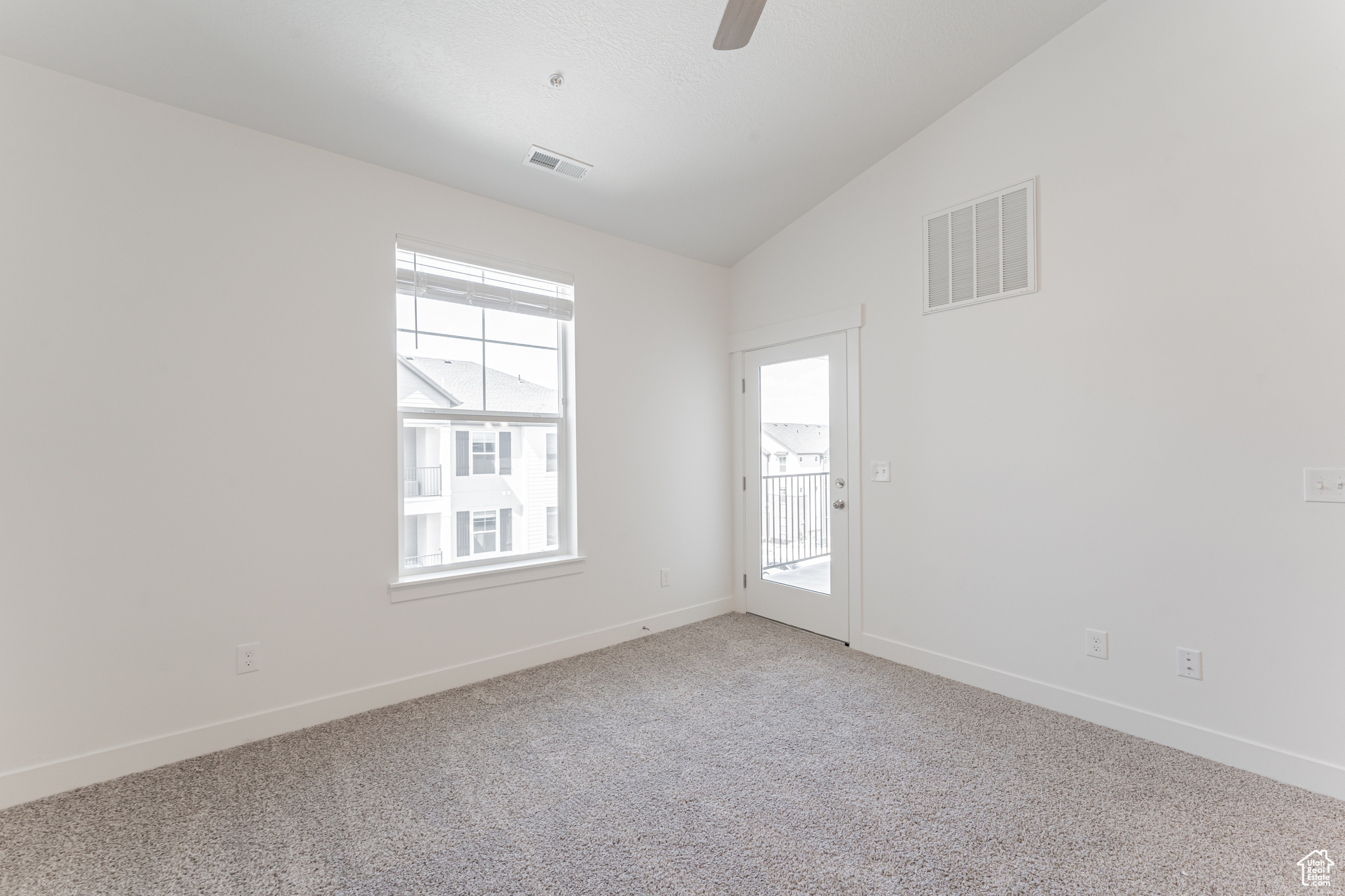 Spare room featuring lofted ceiling, carpet flooring, and ceiling fan