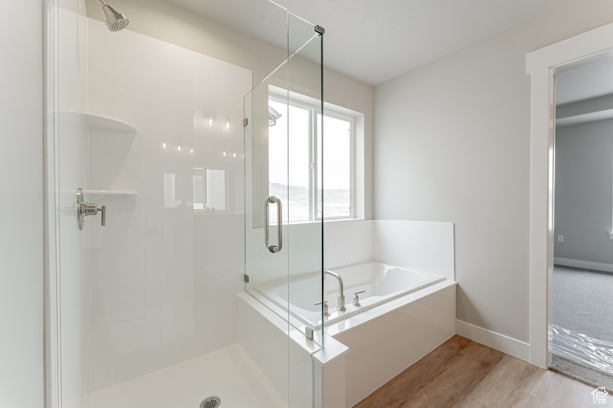 Bathroom featuring wood-type flooring and independent shower and bath