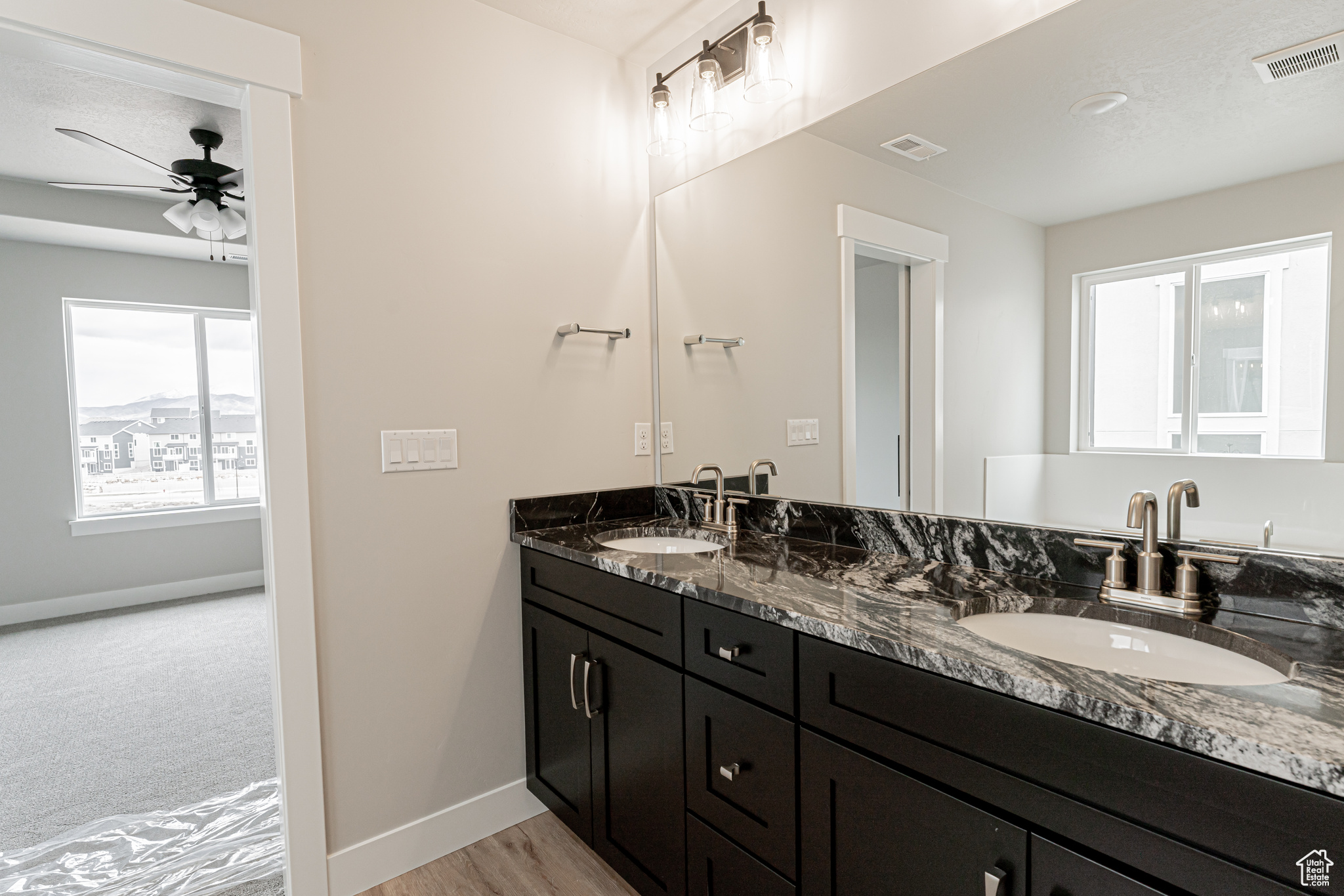 Bathroom with oversized vanity, ceiling fan, and dual sinks