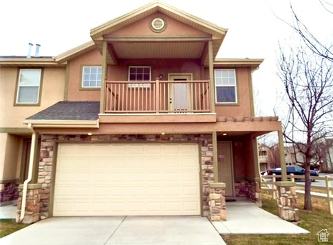 View of front of property with a garage and a balcony