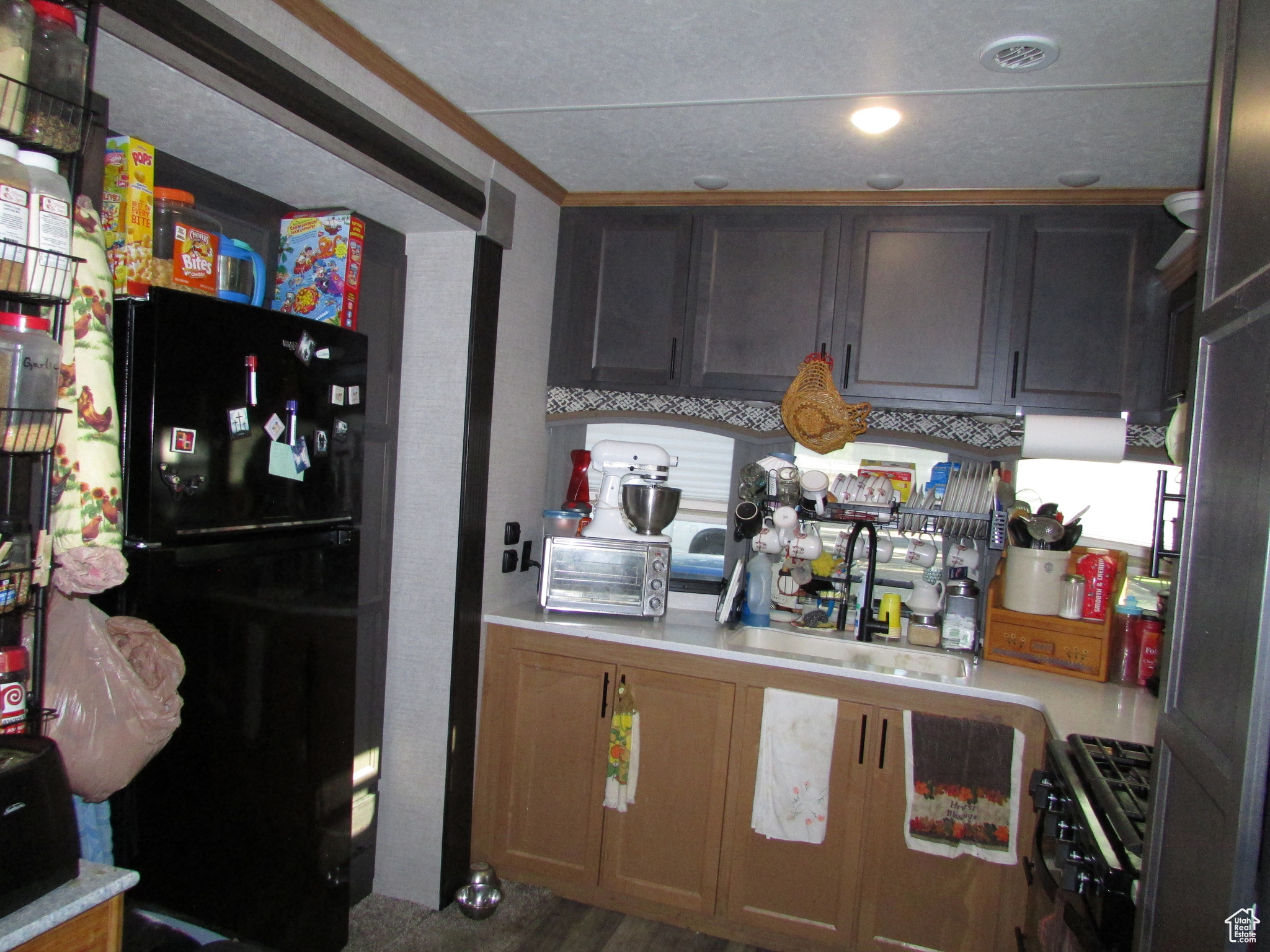 Kitchen with black refrigerator, sink, and range with gas cooktop