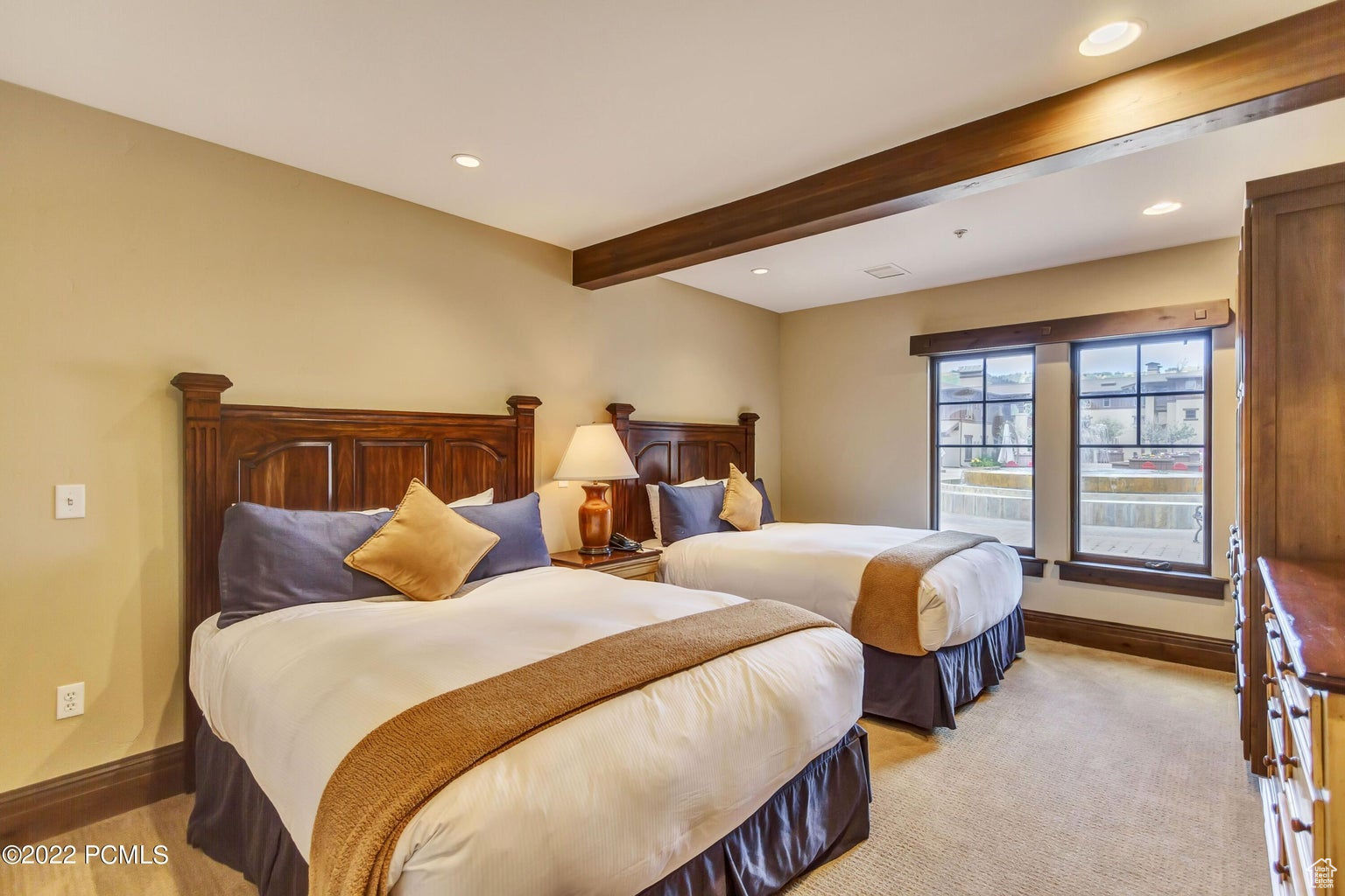 Bedroom featuring light carpet and beam ceiling