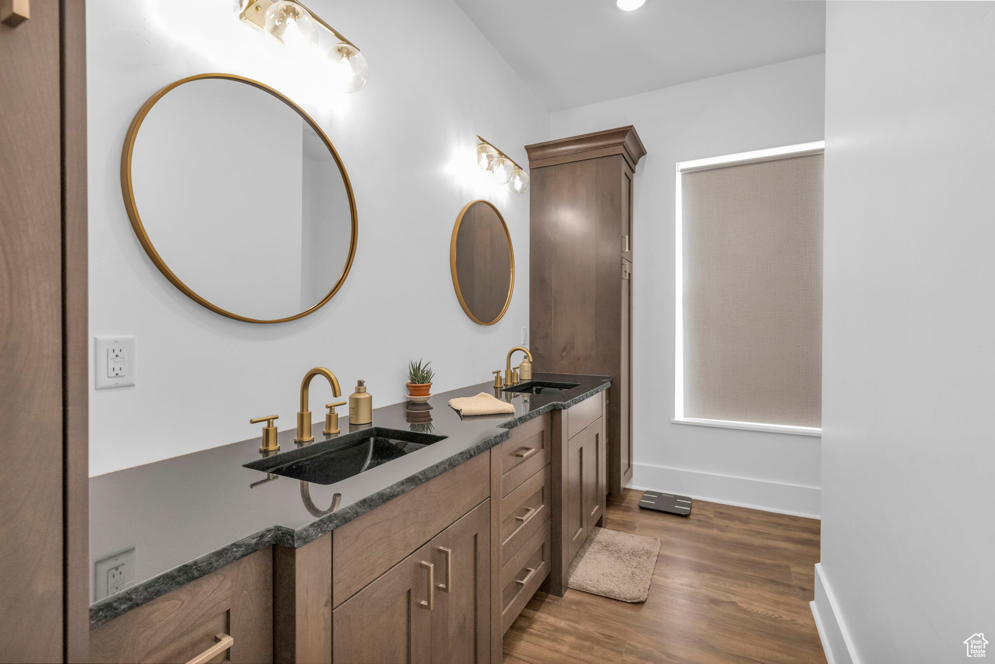 Bathroom with double vanity and hardwood / wood-style flooring
