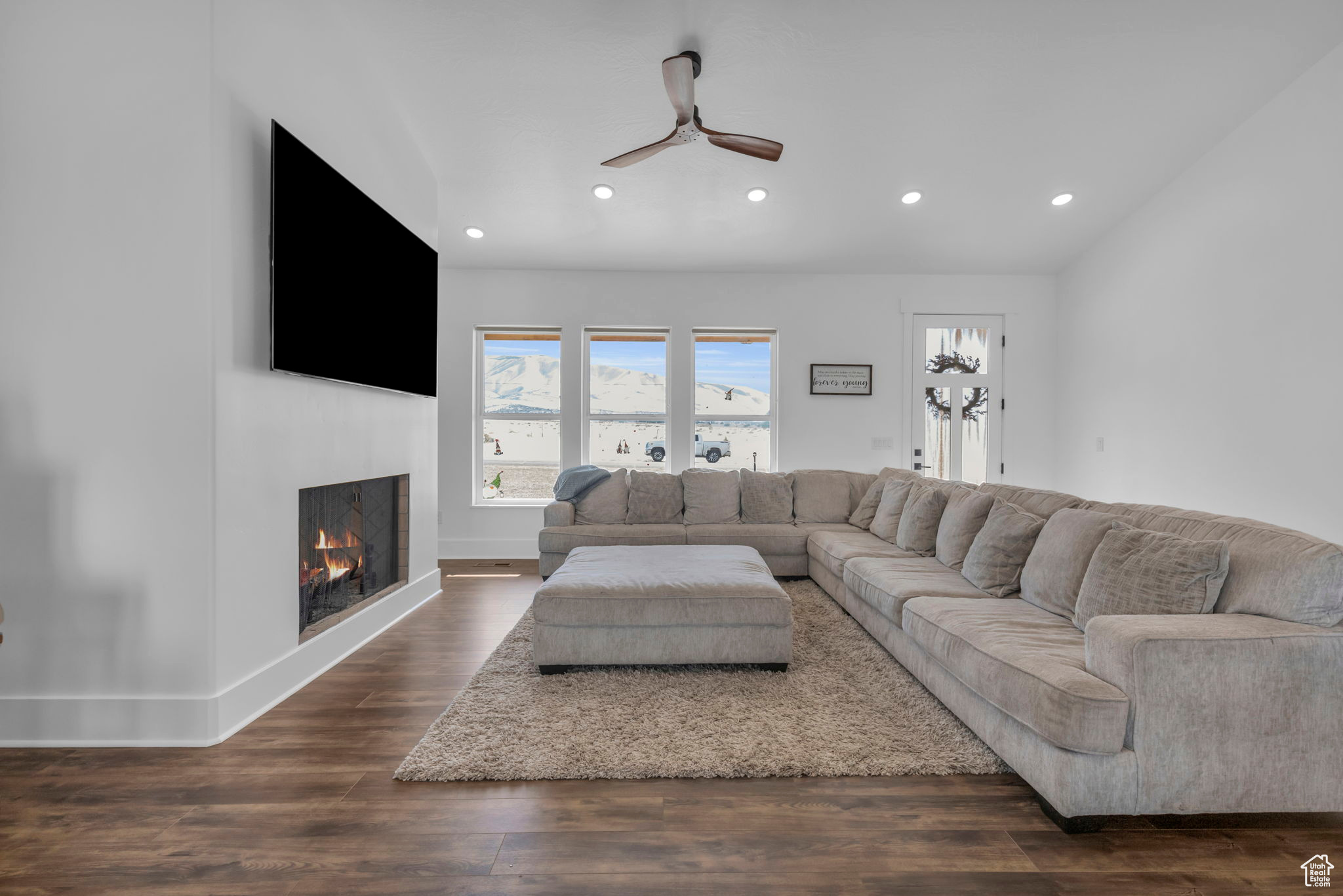 Living room featuring dark wood-type flooring and ceiling fan