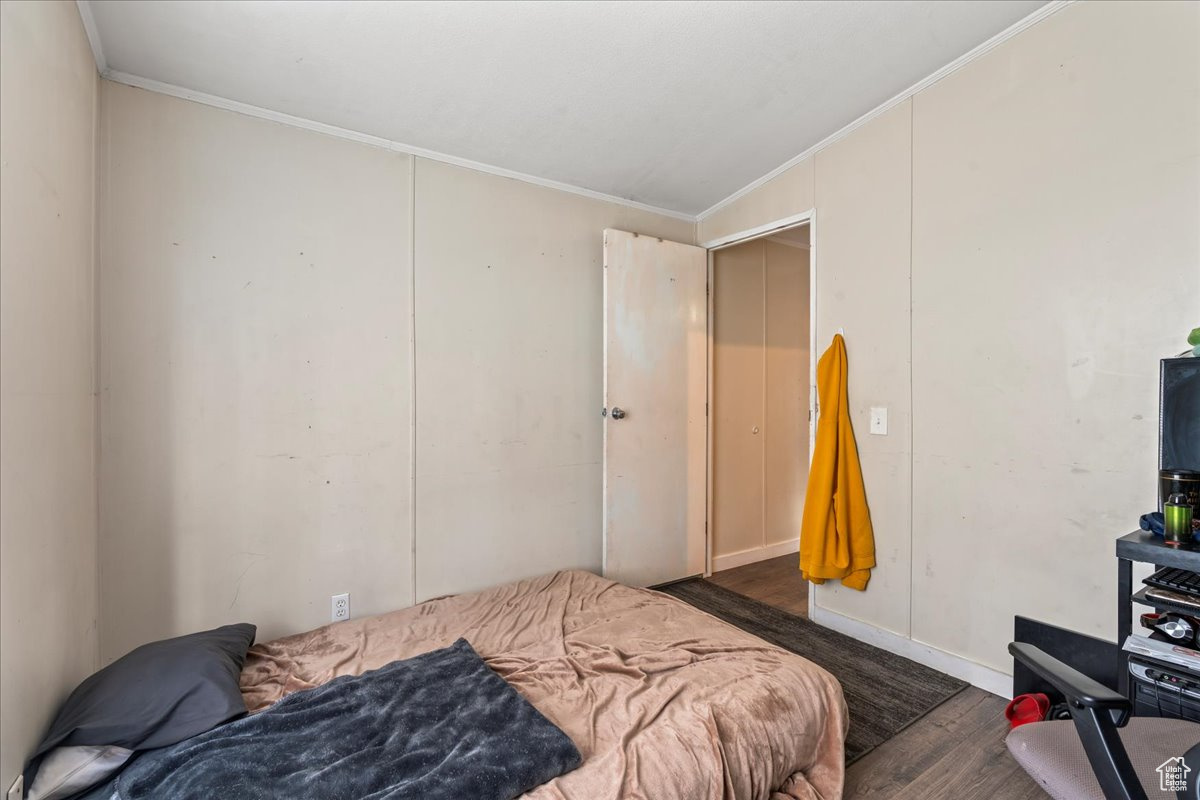 Bedroom featuring dark wood-type flooring and crown molding