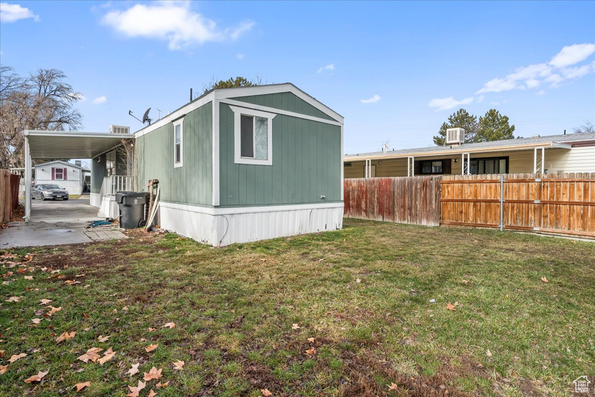 Back of house featuring a carport and a lawn