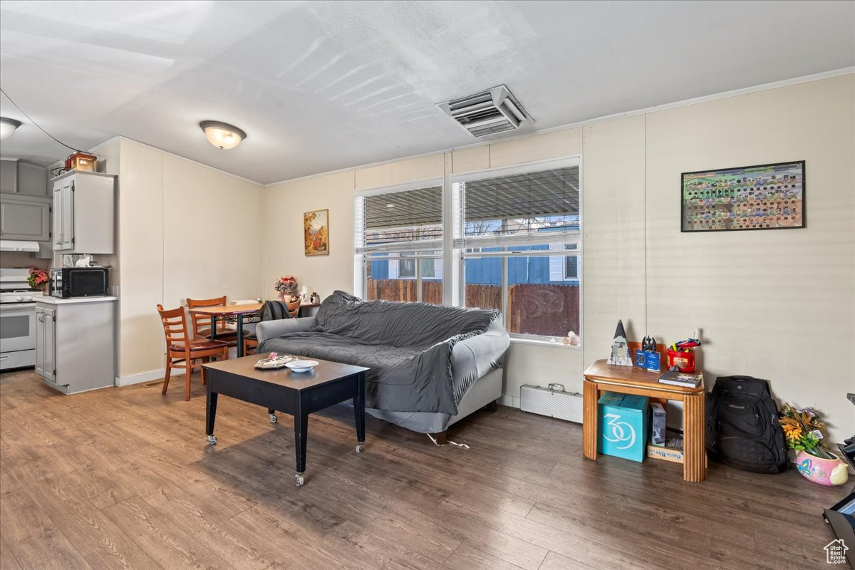 Living room featuring hardwood / wood-style floors and a baseboard heating unit