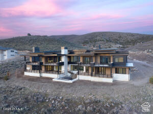 Back house at dusk featuring a mountain view