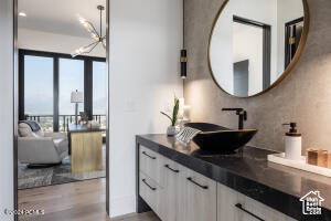 Bathroom with vanity, hardwood / wood-style flooring, and a notable chandelier