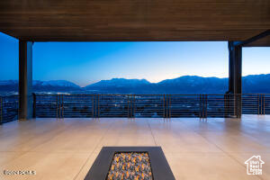 View of patio with a mountain view and a balcony