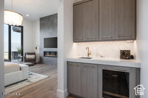 Bar featuring sink and light wood-type flooring