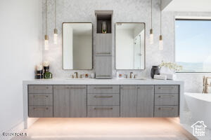 Bathroom featuring a washtub and double sink vanity