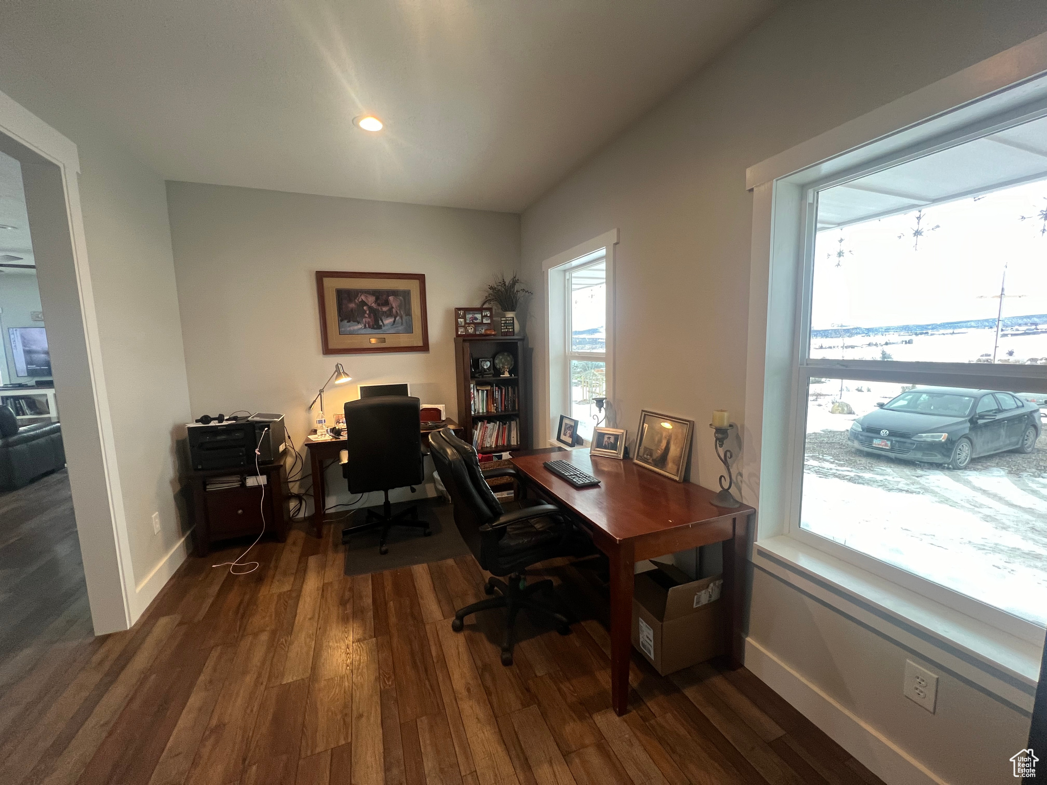 Office with dark hardwood / wood-style floors and a healthy amount of sunlight