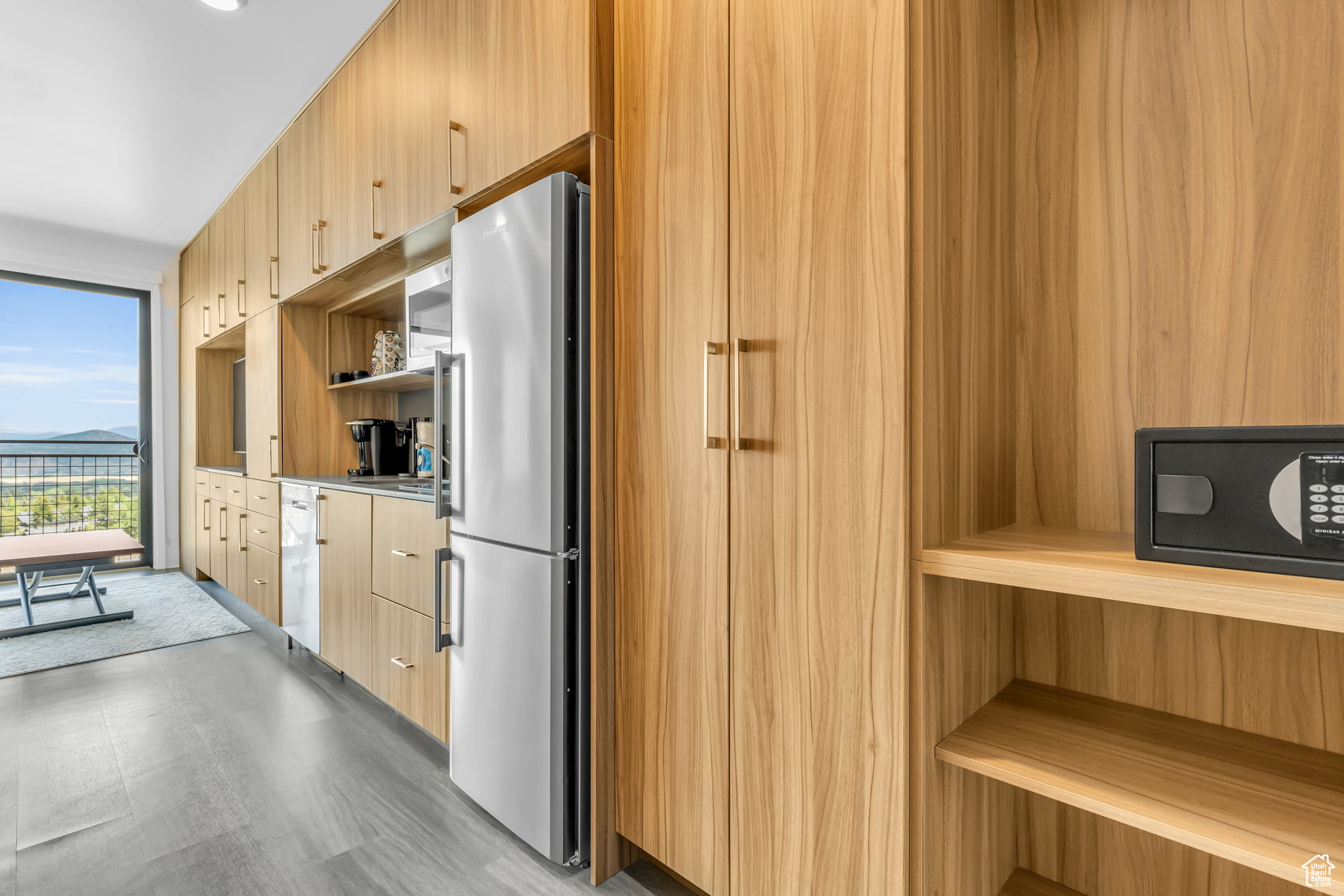 Kitchen featuring light brown cabinets, light tile flooring, and stainless steel fridge