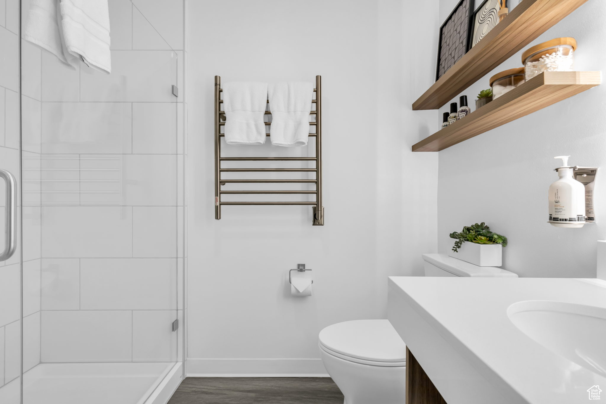 Bathroom with vanity, a shower with door, hardwood / wood-style flooring, toilet, and radiator
