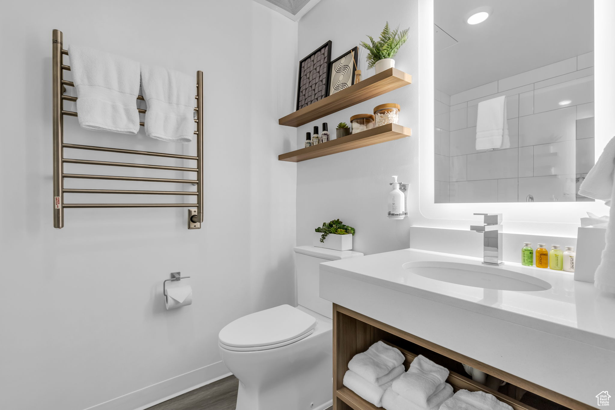 Bathroom with vanity, toilet, hardwood / wood-style flooring, and radiator heating unit