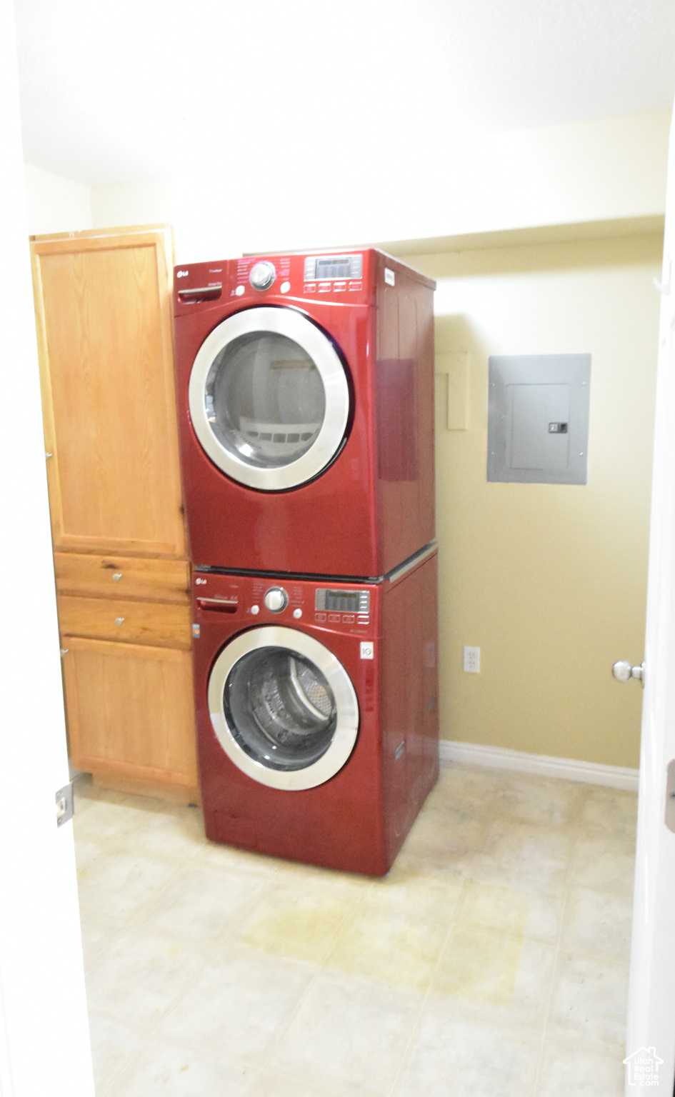 Washroom with tile floors and stacked washer / dryer