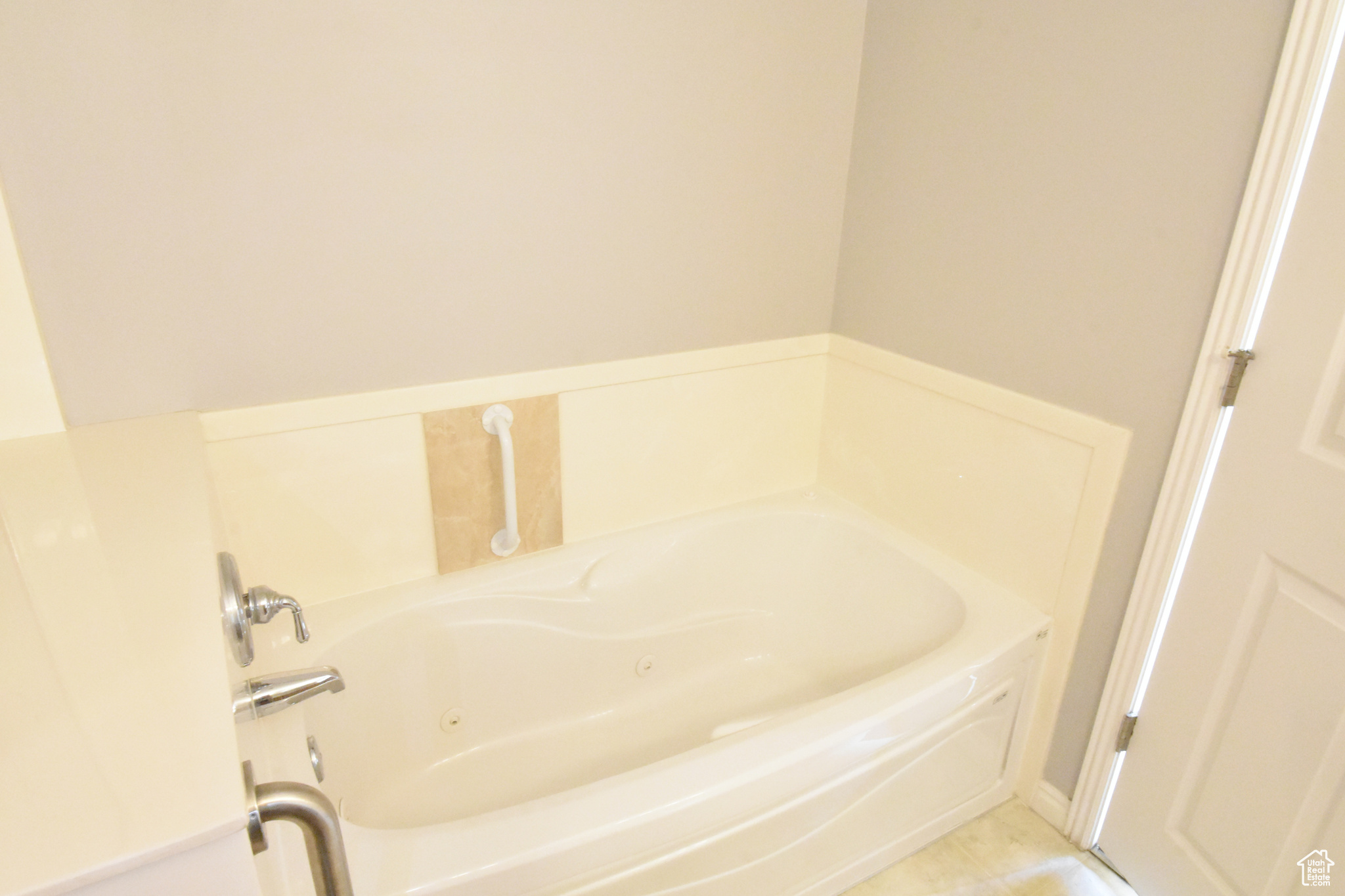 Bathroom with a tub and tile flooring