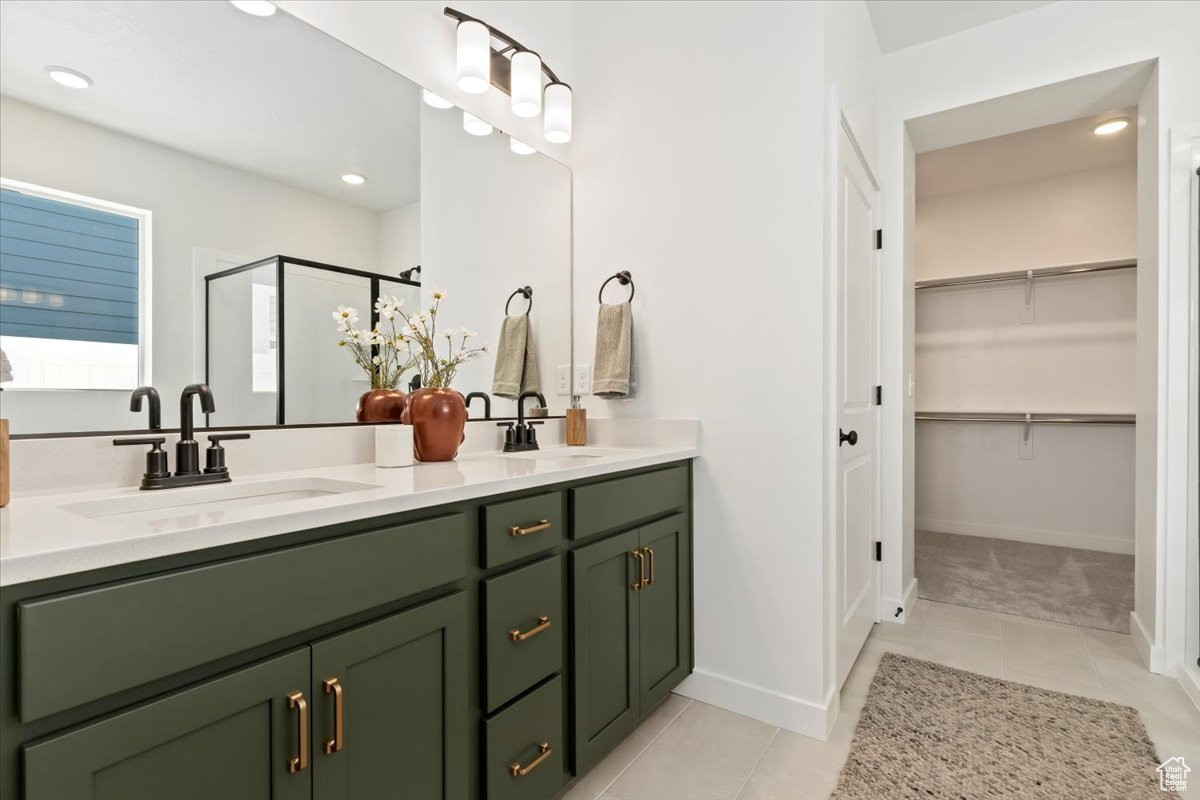 Bathroom with walk in shower, tile flooring, oversized vanity, and dual sinks