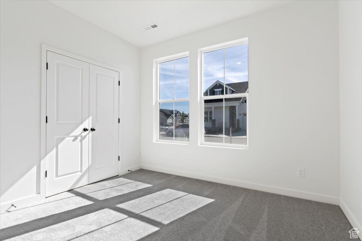 Spare room featuring dark carpet