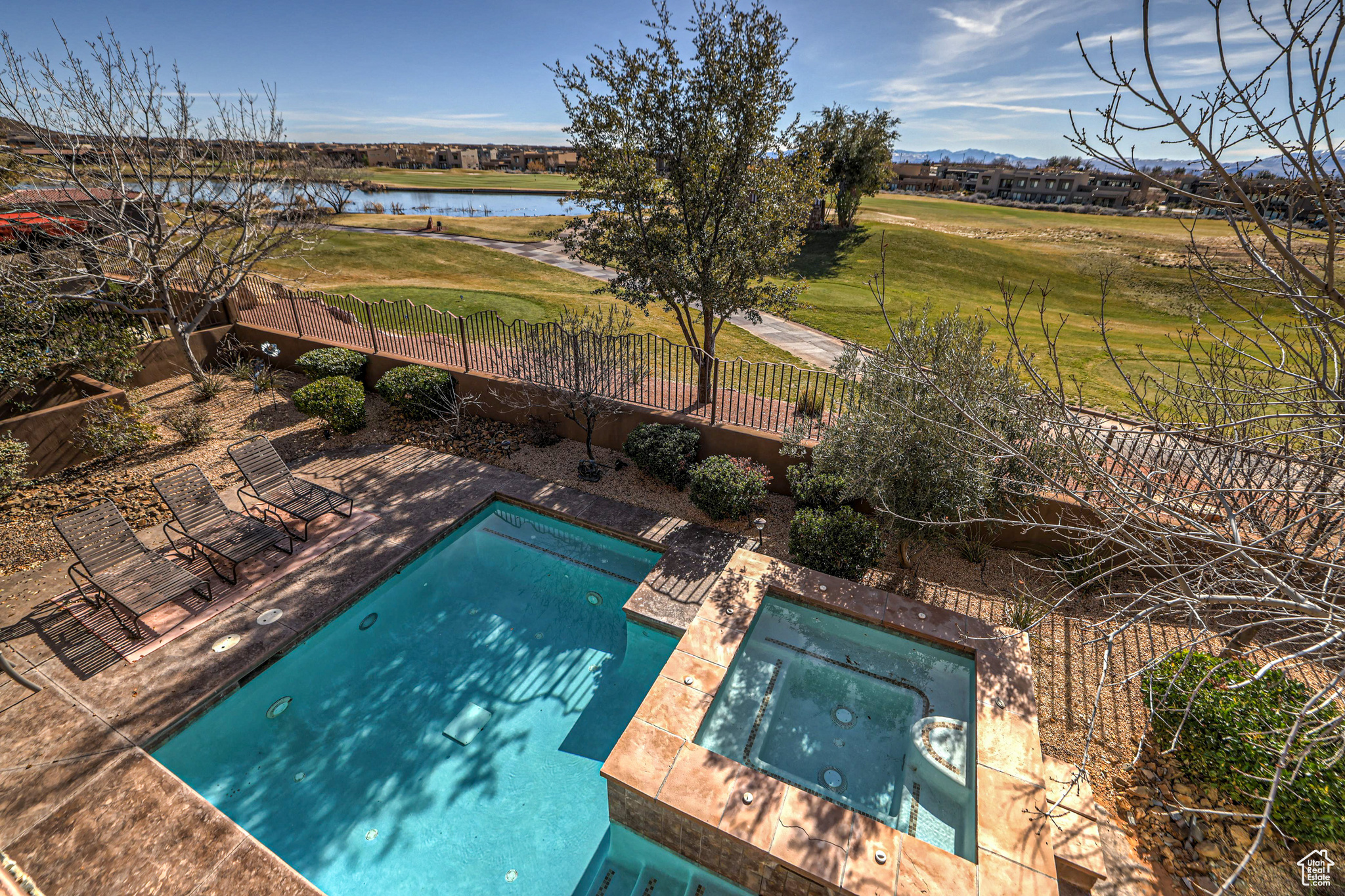 View of swimming pool featuring an in ground hot tub, a patio area, and a water view