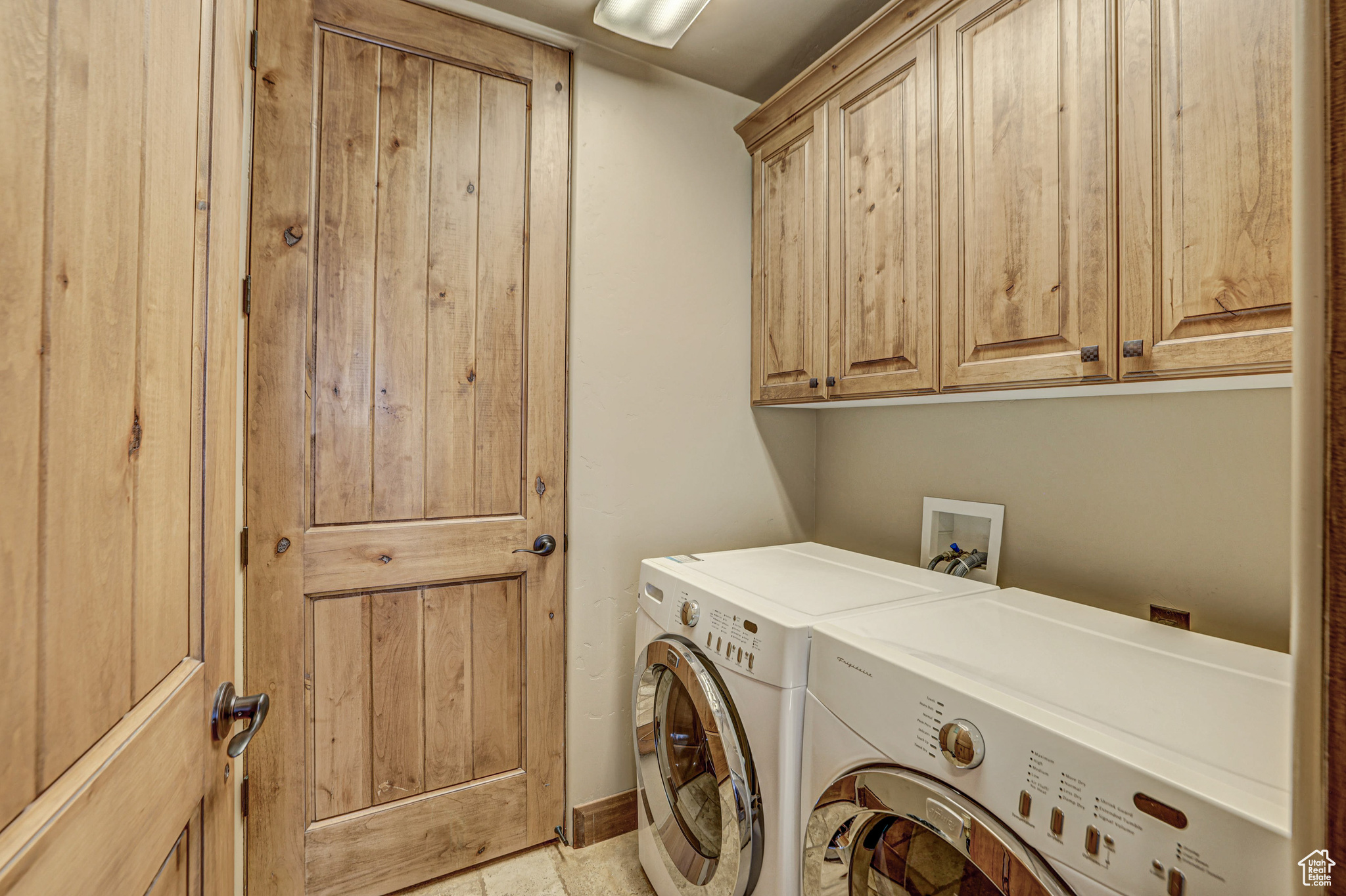 Laundry area featuring washer and dryer, cabinets, light tile floors, and washer hookup