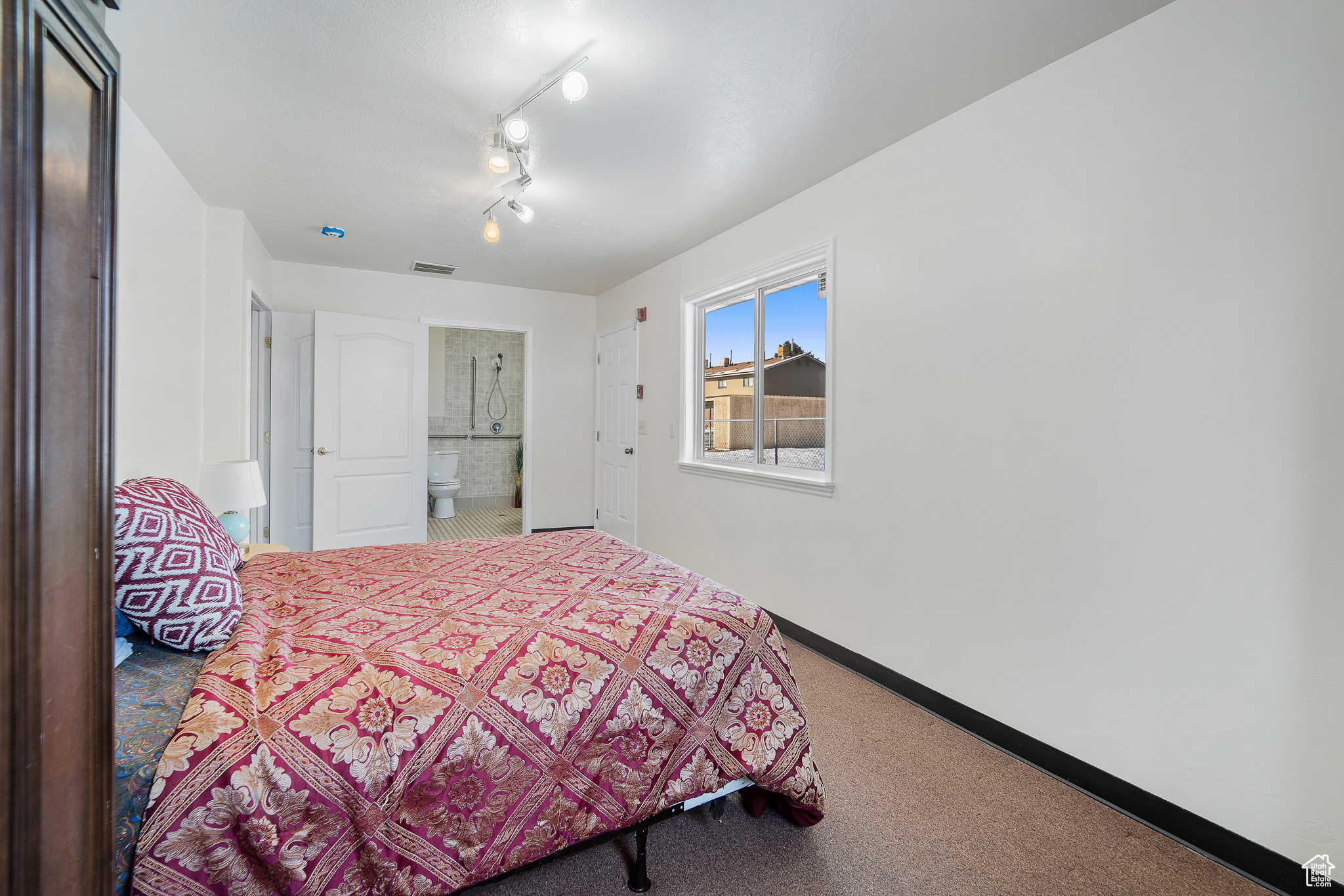 Bedroom featuring track lighting and carpet