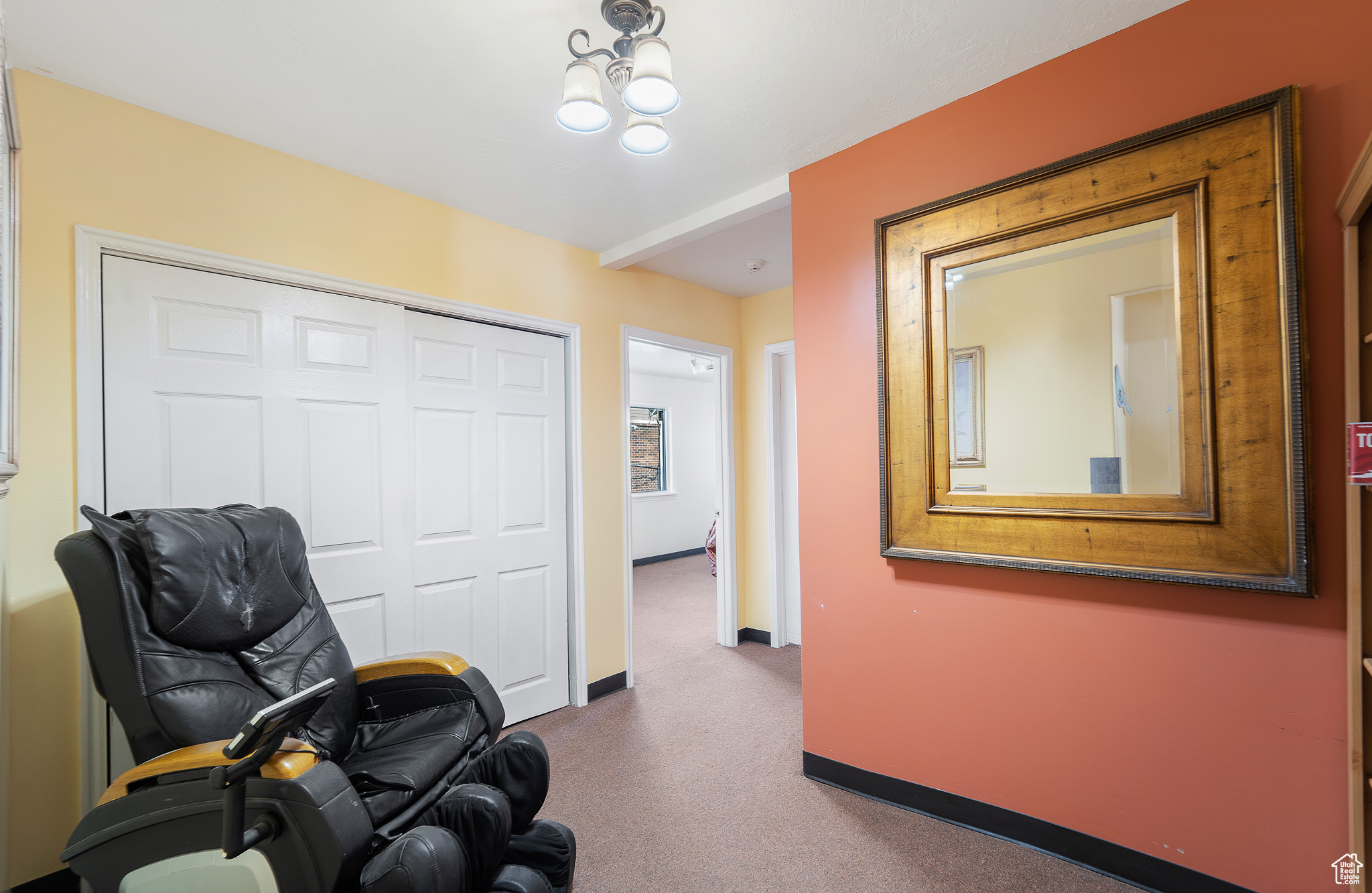 Sitting room with dark carpet and a notable chandelier