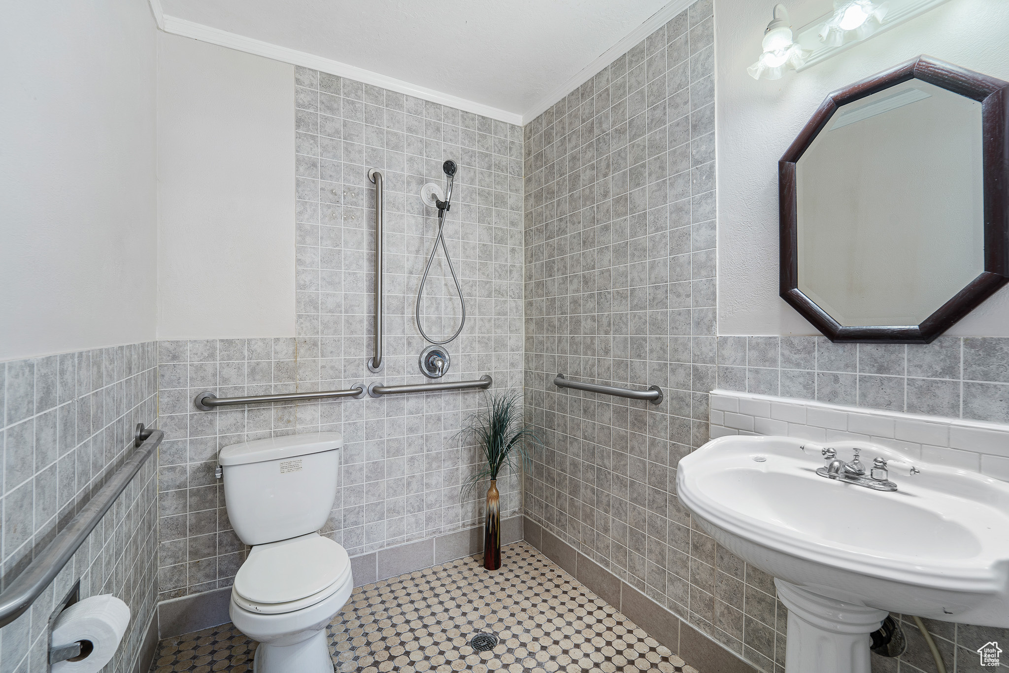 Bathroom with toilet, tile walls, ornamental molding, and tile flooring