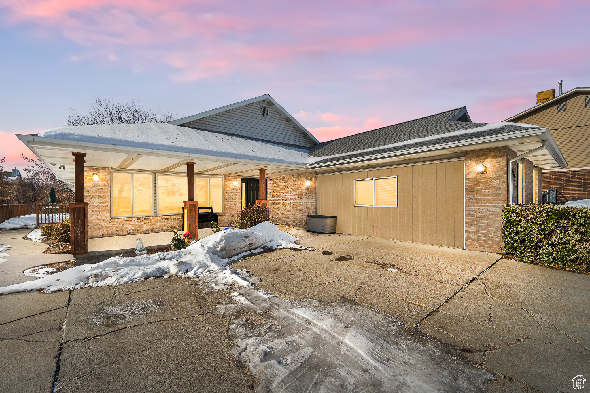 Snow covered rear of property featuring a patio