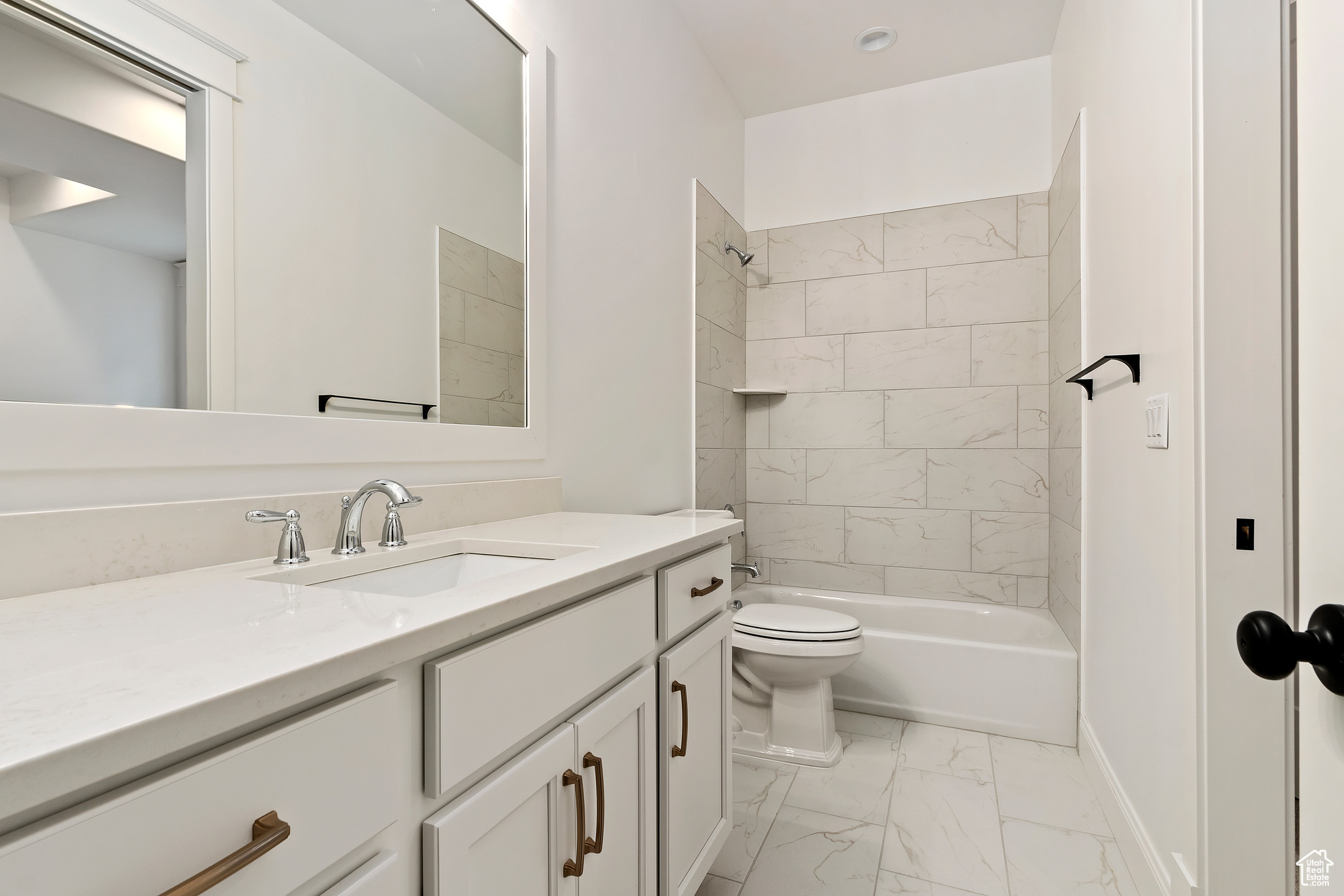 Full bathroom featuring vanity, toilet, tile floors, and tiled shower / bath