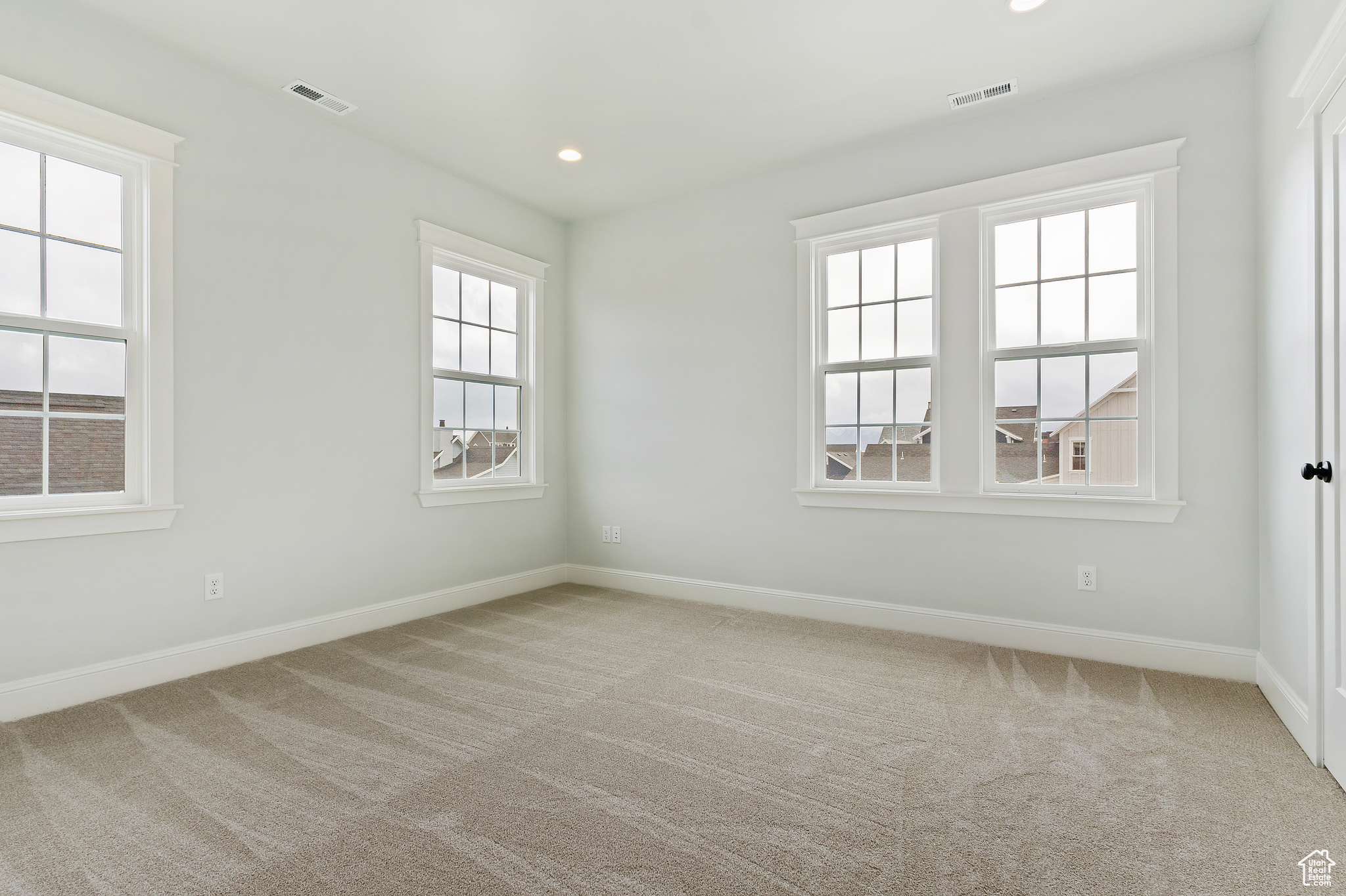 Master bedroom featuring plenty of natural light and light colored carpet