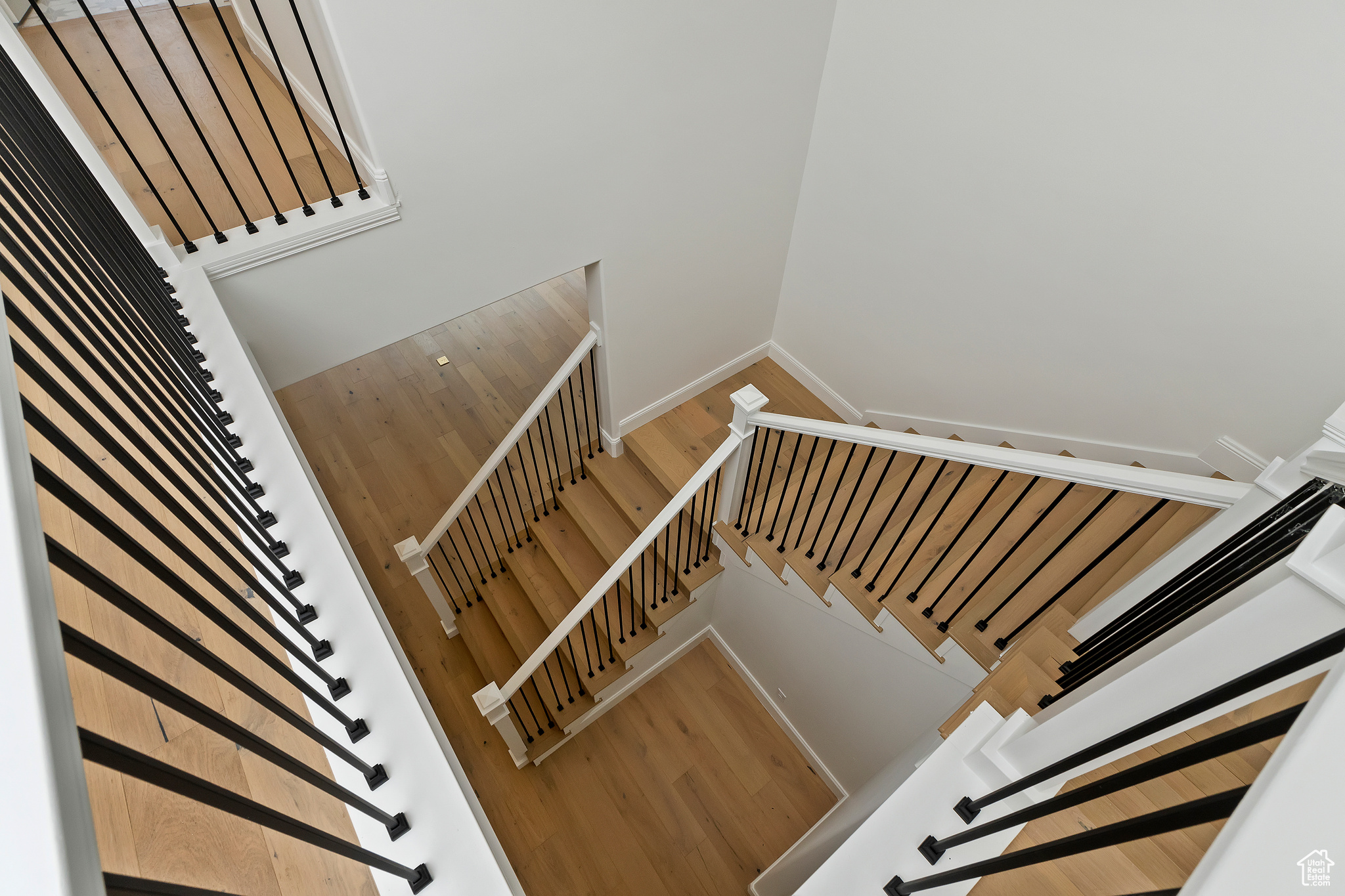 Staircase featuring light hardwood / wood-style flooring and a high ceiling
