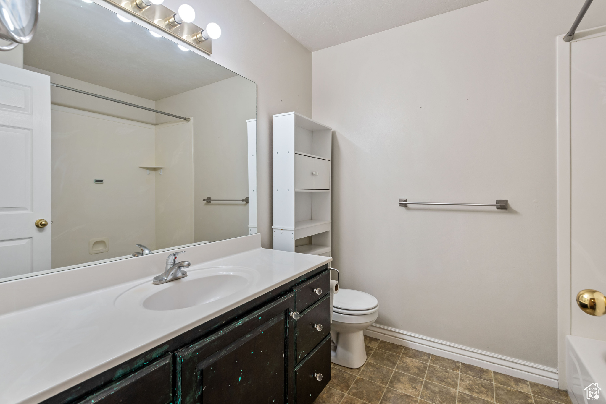 Full bathroom with washtub / shower combination, vanity, tile flooring, and toilet