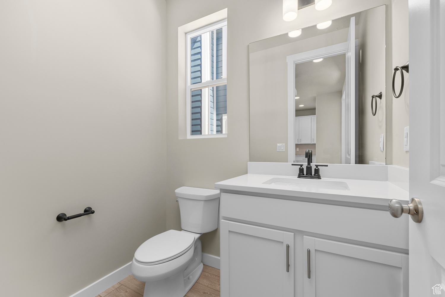 Bathroom with toilet, hardwood / wood-style flooring, vanity, and a healthy amount of sunlight