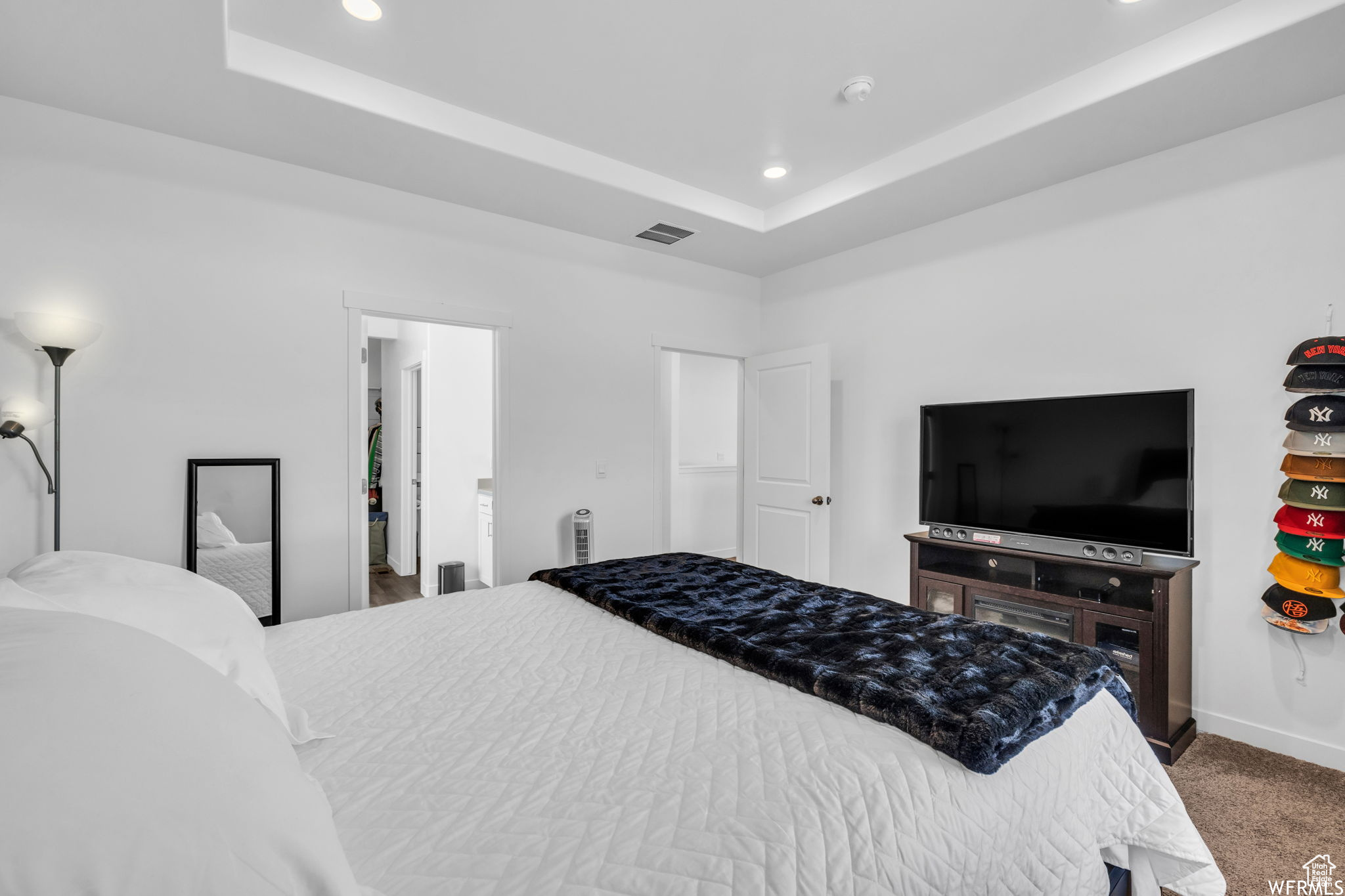 Bedroom featuring dark colored carpet and a tray ceiling