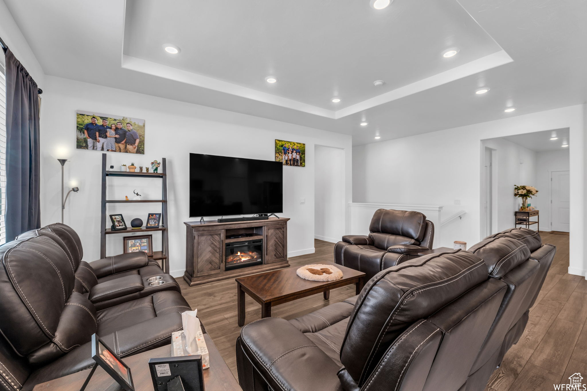 Living room featuring dark hardwood / wood-style flooring and a tray ceiling