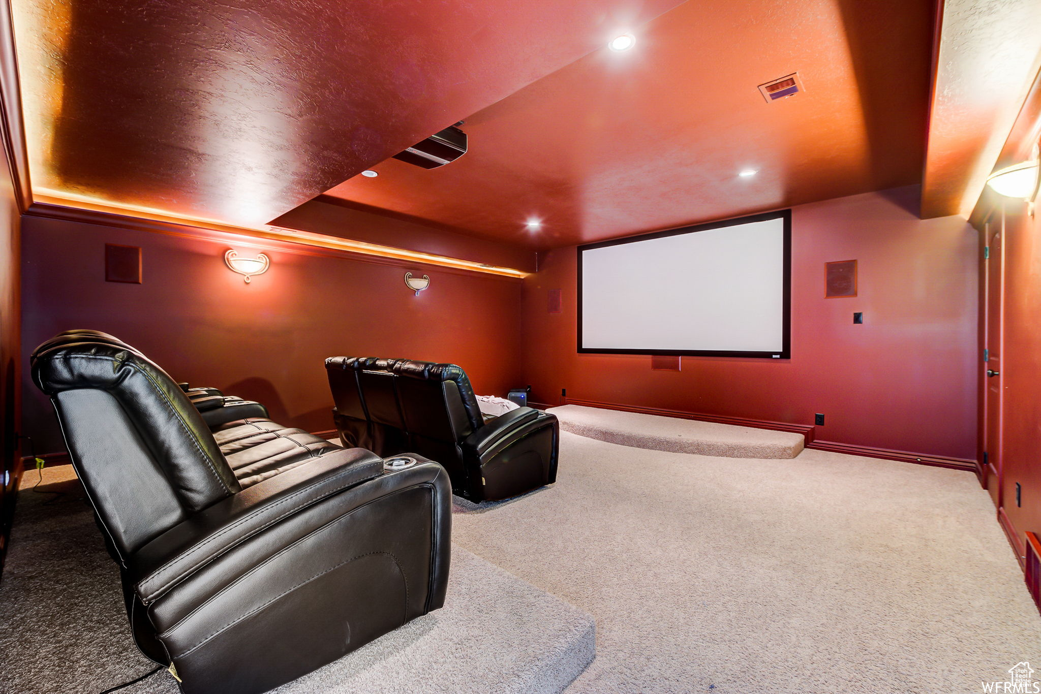 Cinema featuring light colored carpet and a tray ceiling