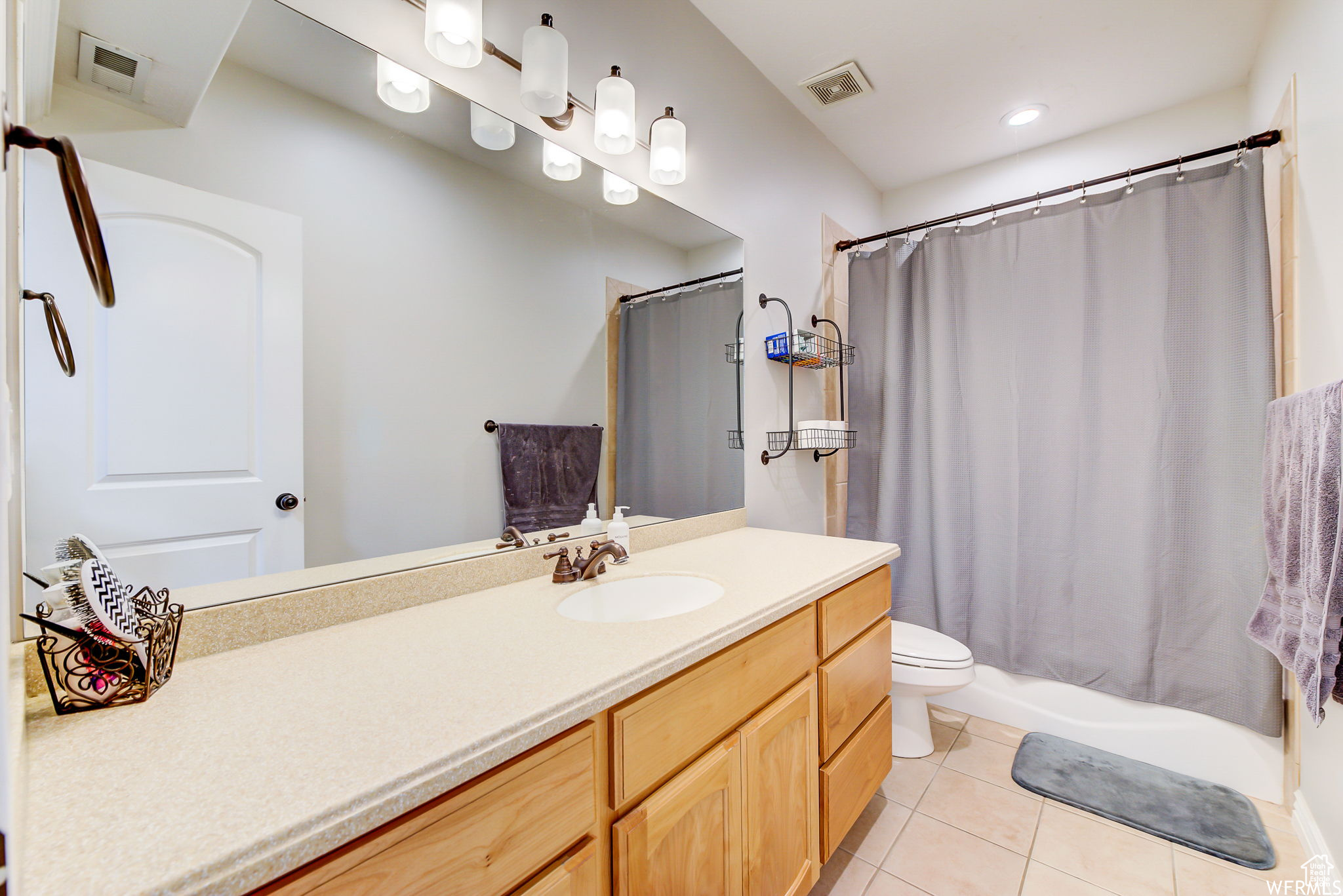 Full bathroom with vanity, toilet, shower / tub combo, and tile flooring