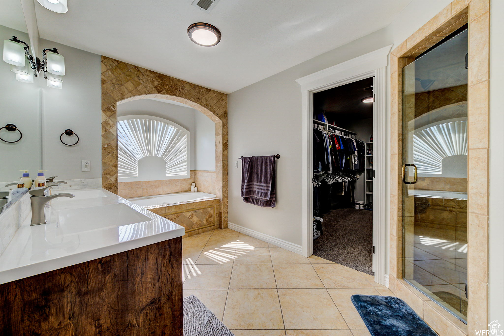 Bathroom featuring dual vanity, plus walk in shower, and tile flooring