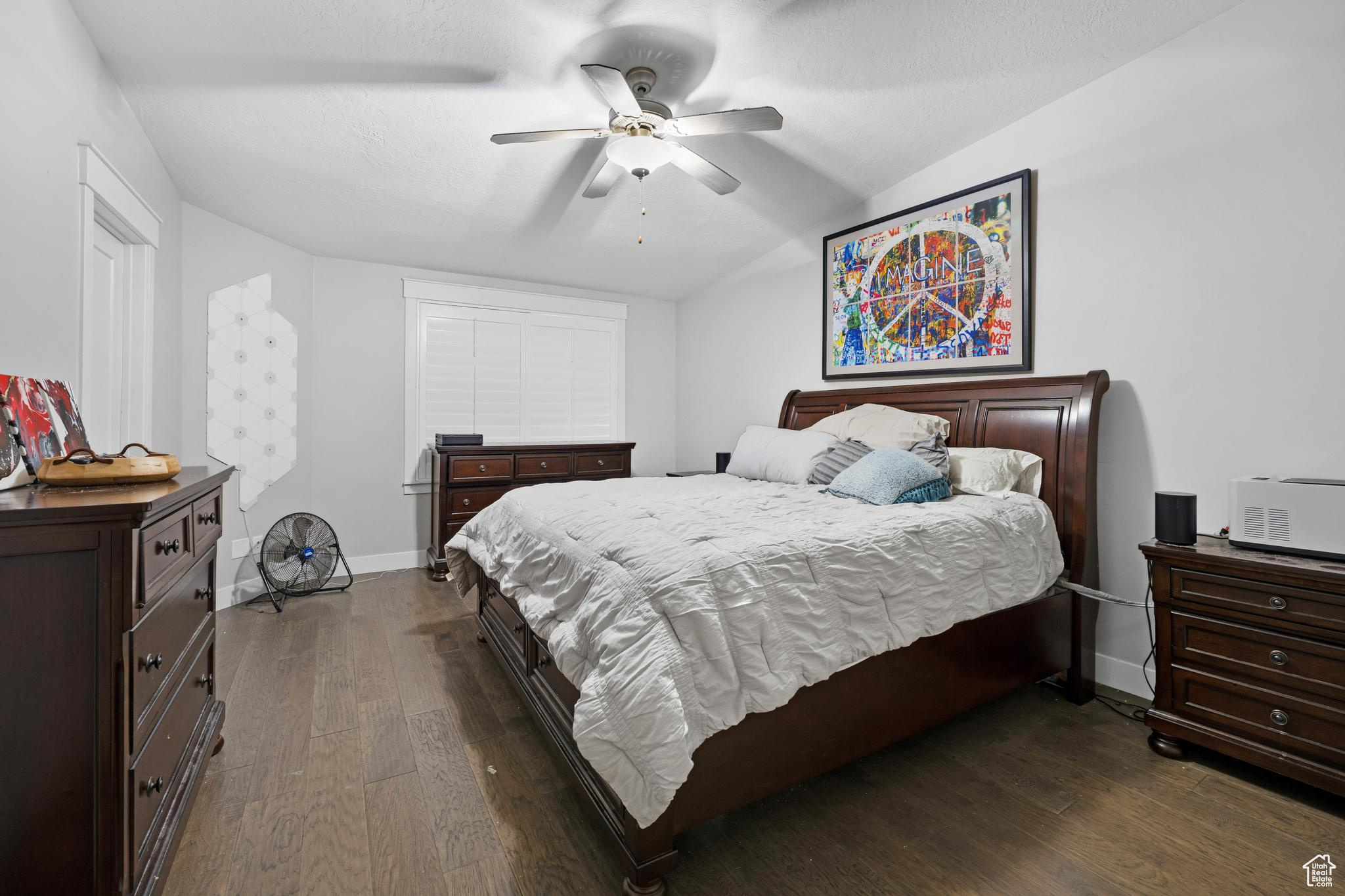 Bedroom with dark hardwood / wood-style floors, ceiling fan, and vaulted ceiling