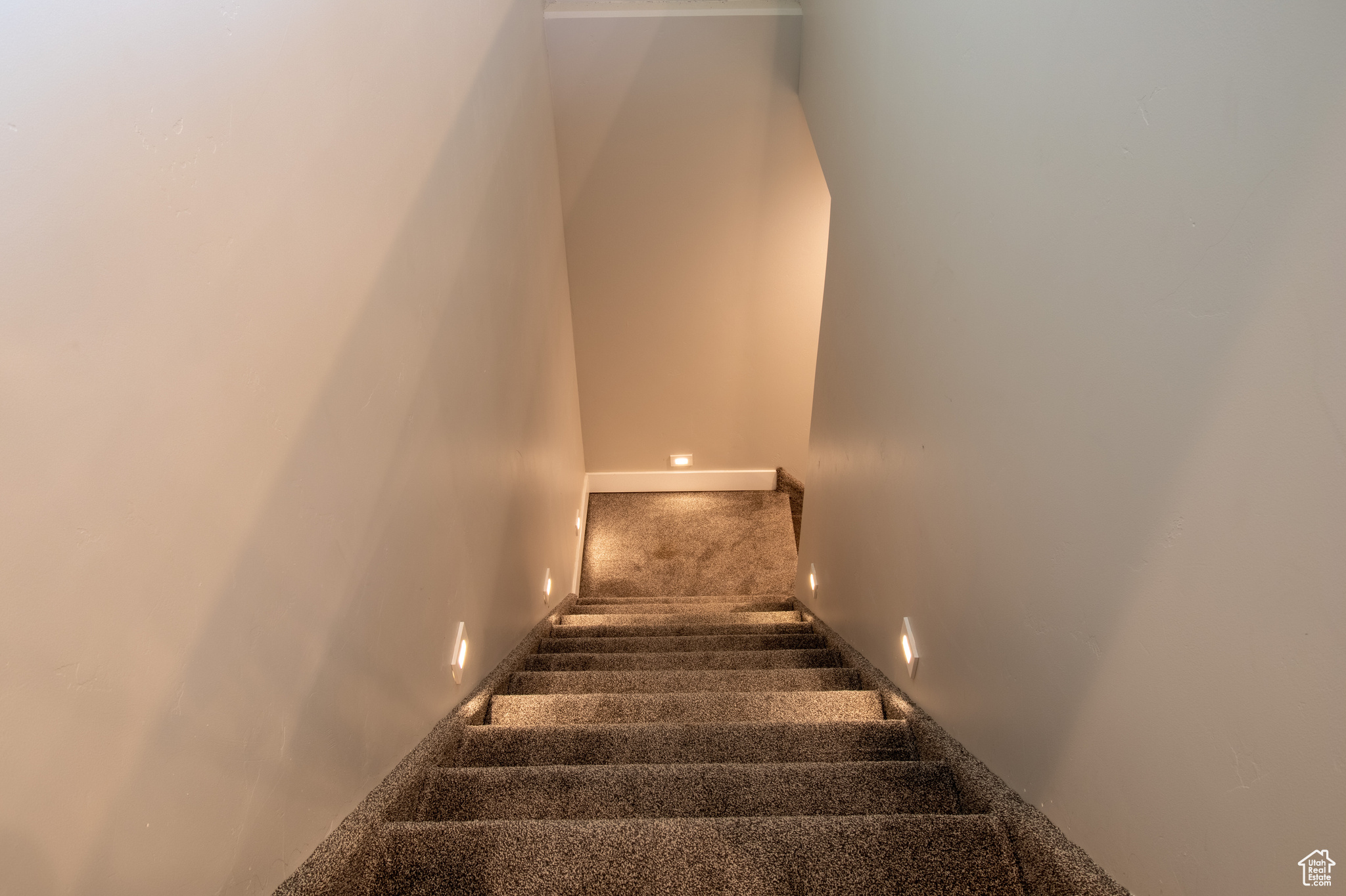 Staircase featuring dark carpet