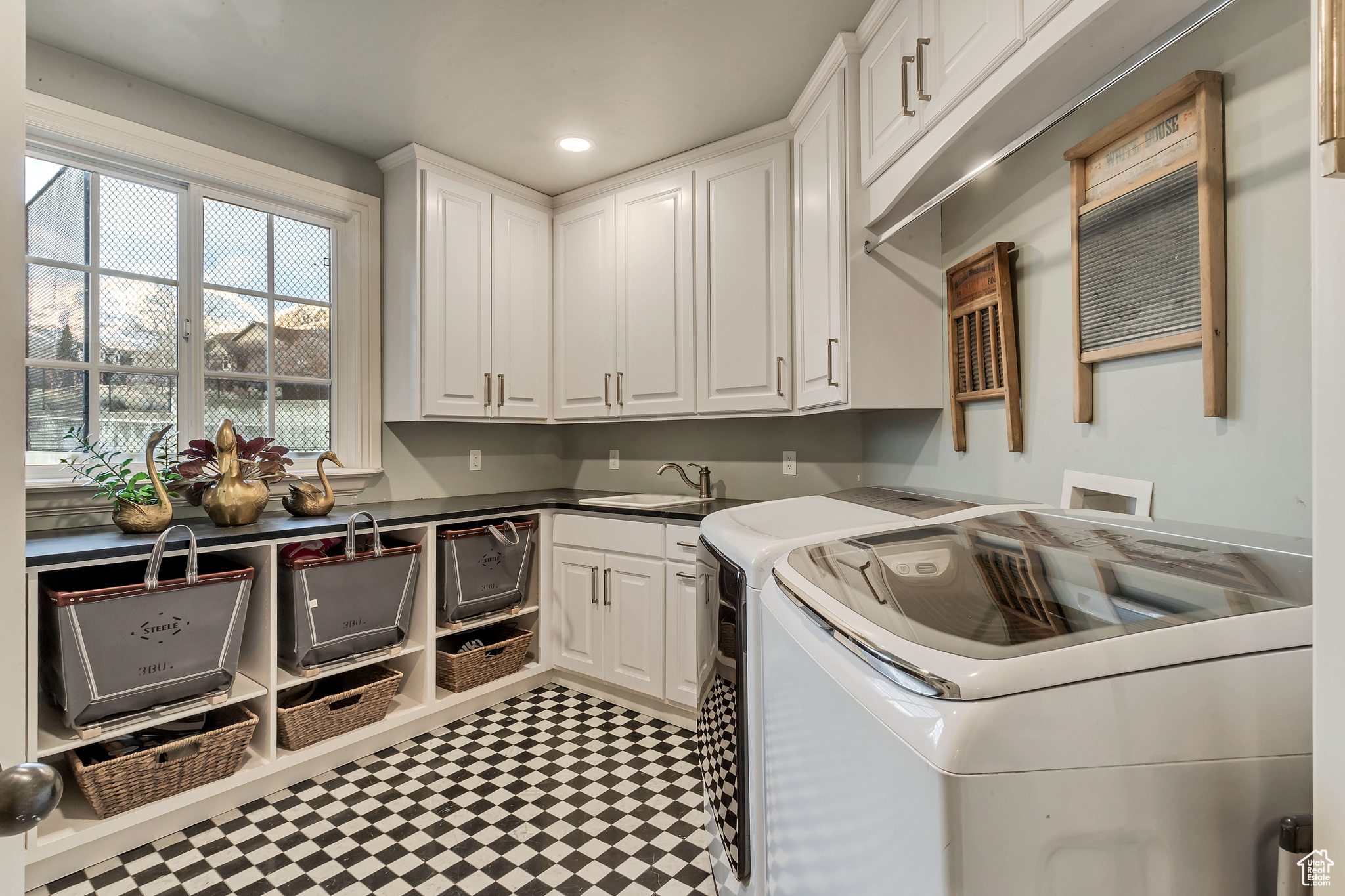 Laundry room featuring cabinets, sink, washing machine and dryer, and marble floors
