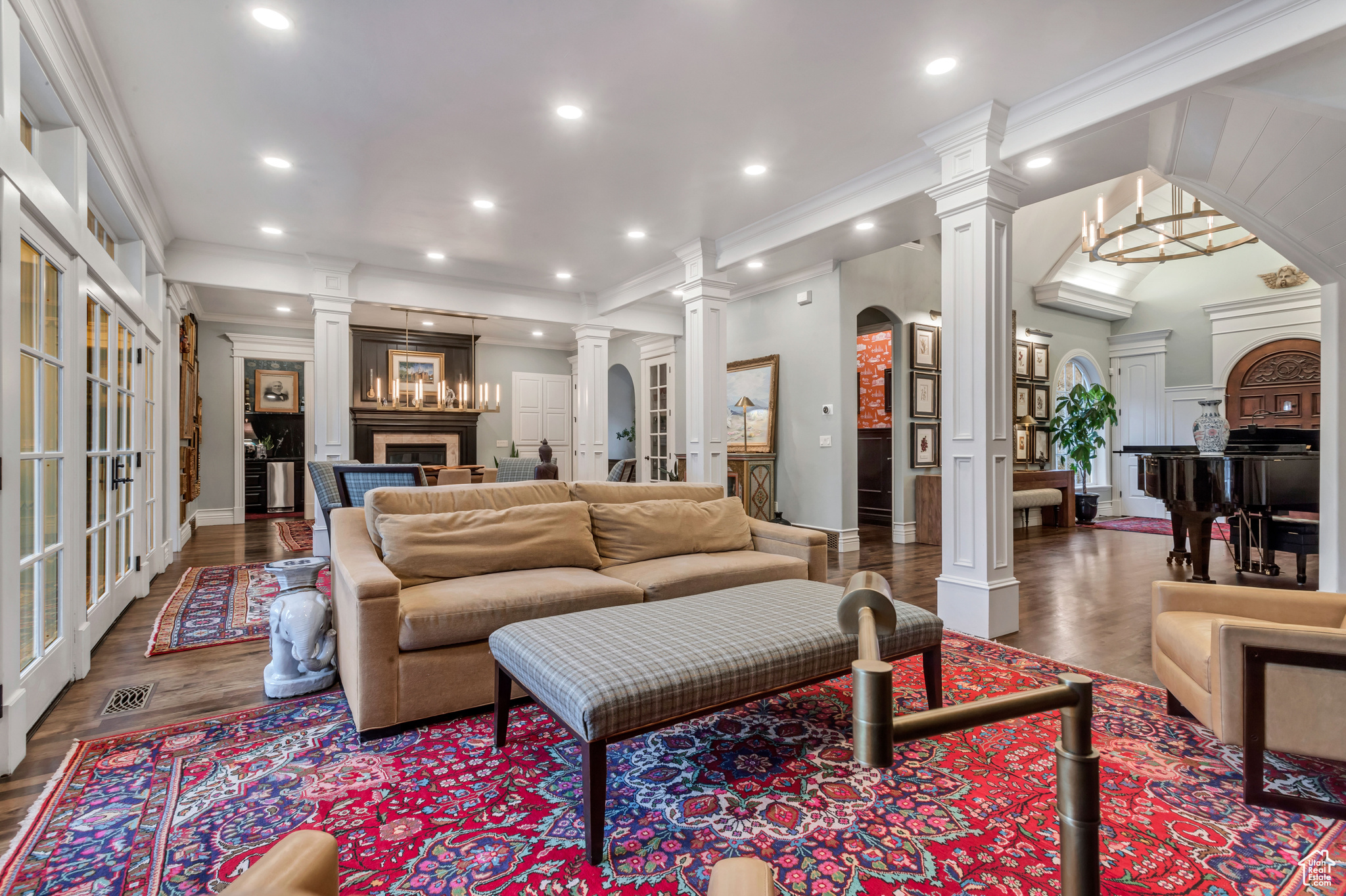 Living room featuring crown molding, dark hardwood/wood floors, and ornate columns