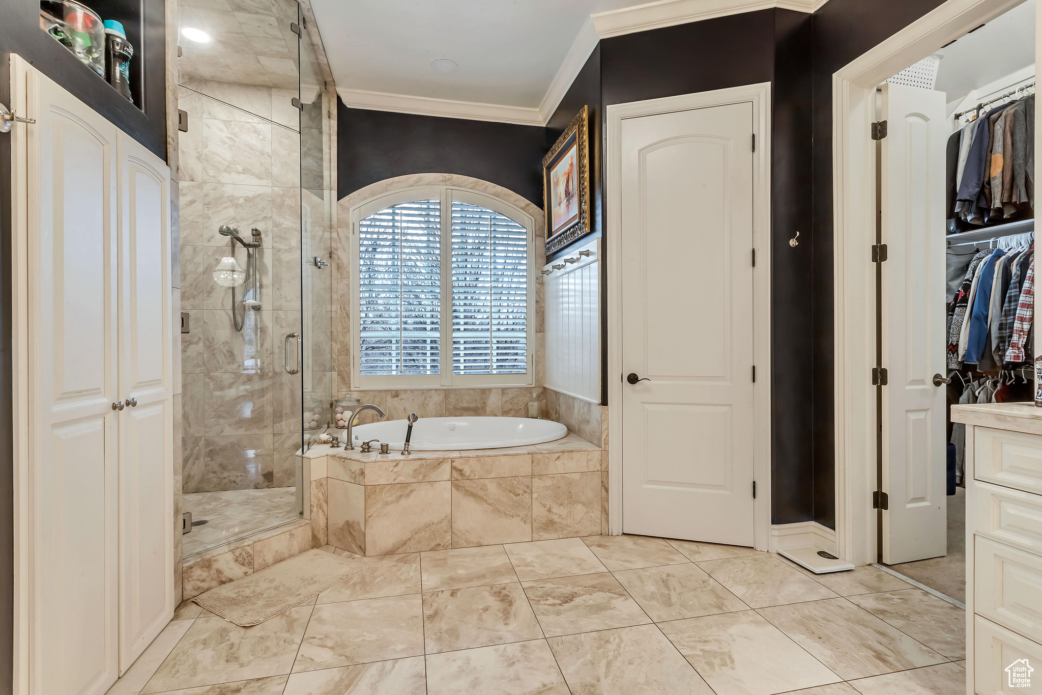 Bathroom featuring vanity, separate shower and tub, travertine floors, and crown molding